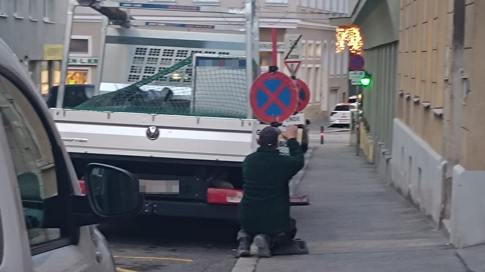 Arbeiter stellt in Kurzparkzone eigene Schilder auf