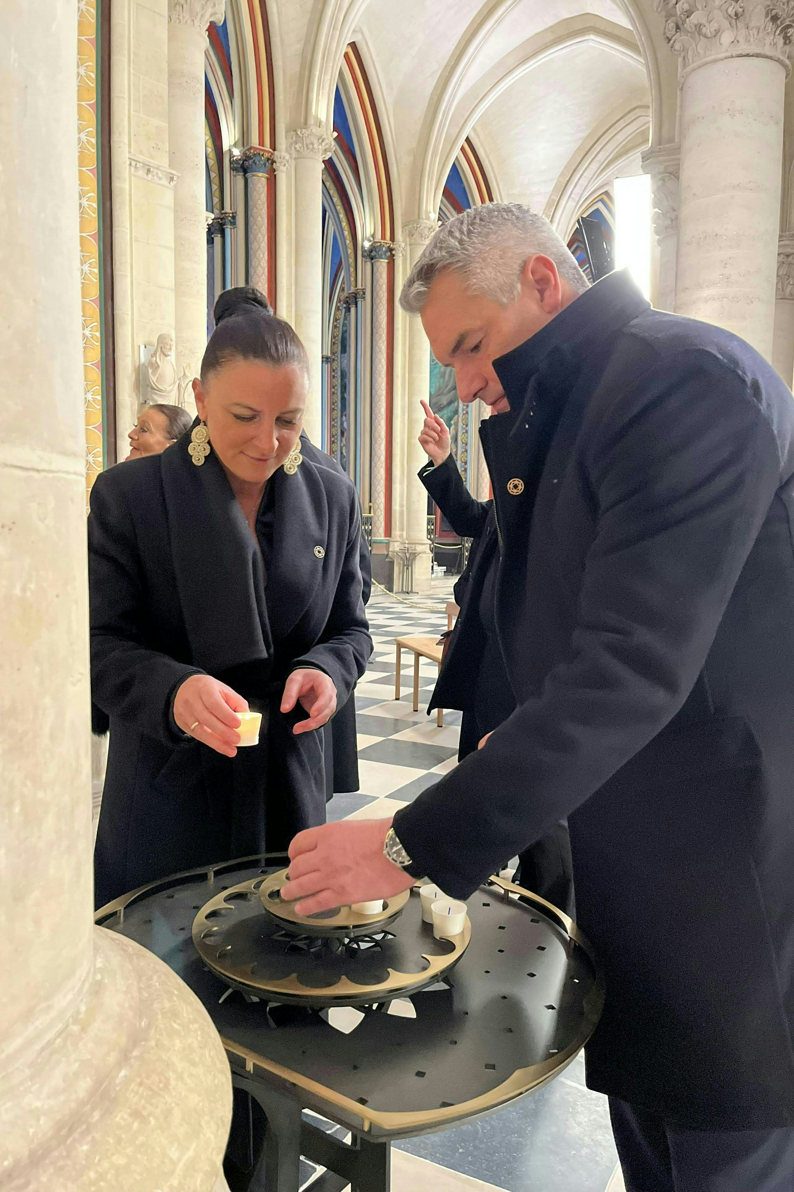 Komischer Adventkranz, oder? Bundeskanzler Karl Nehammer mit Ehefrau Katharina anlässlich der Wiedereröffnung der Kathedrale Notre-Dame in Paris