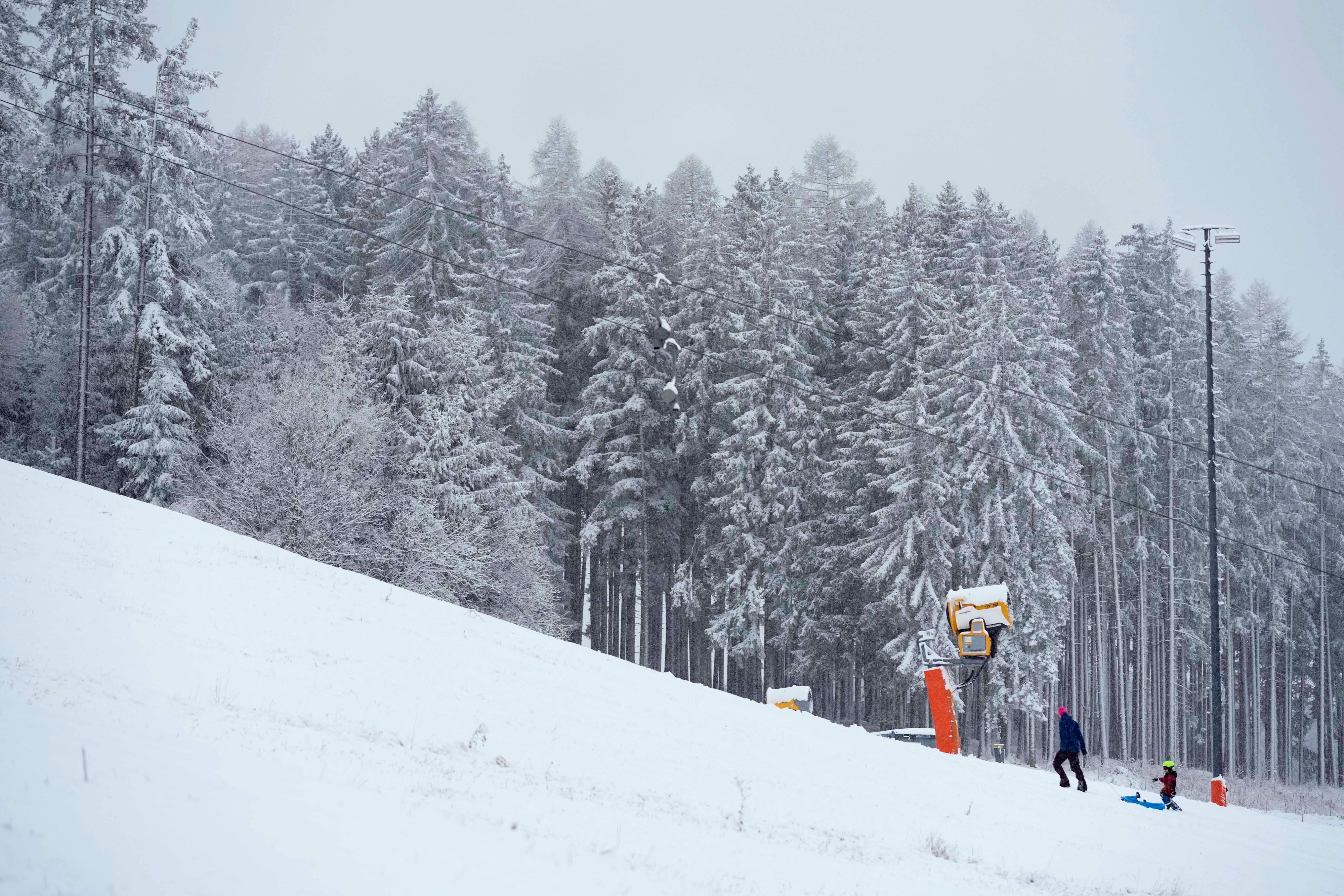 Eine Familie genießt den frisch gefallenen Schnee in Igls bei Innsbruck, 8. Dezember 2024.