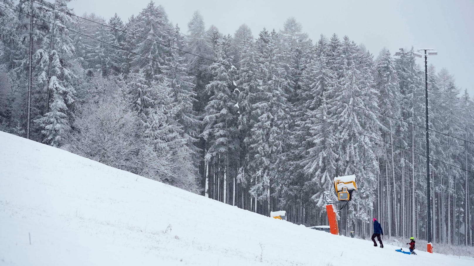 Eine Familie genießt den frisch gefallenen Schnee in Igls bei Innsbruck, 8. Dezember 2024.