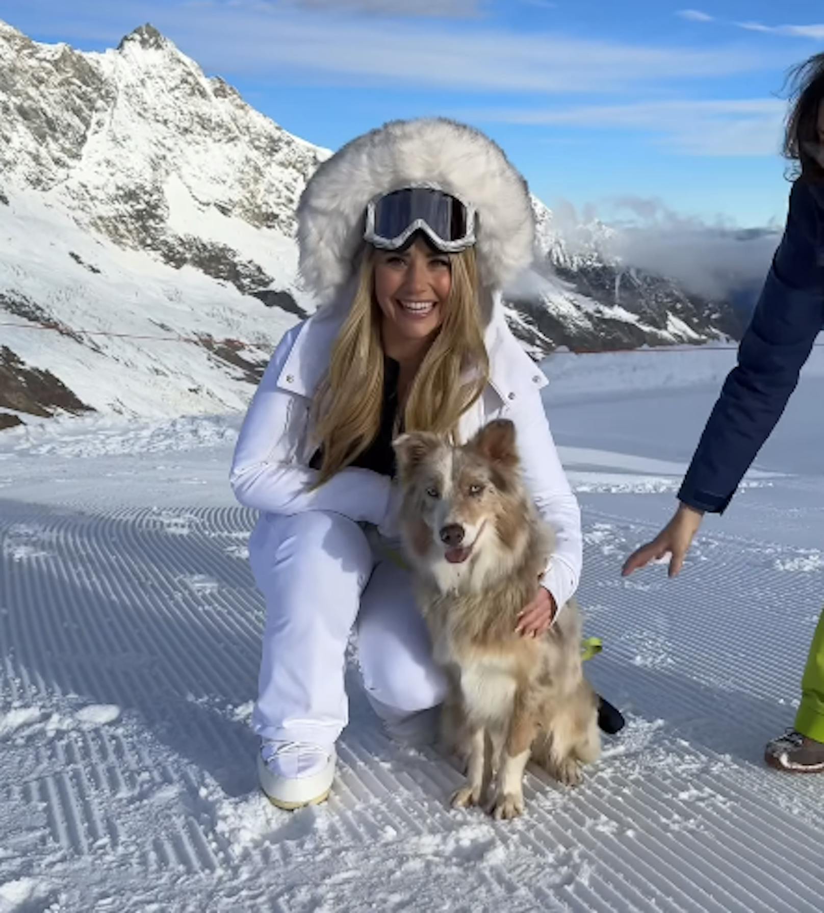 Beatrice Egli posiert mit einem Hund in den Schweizer Bergen.