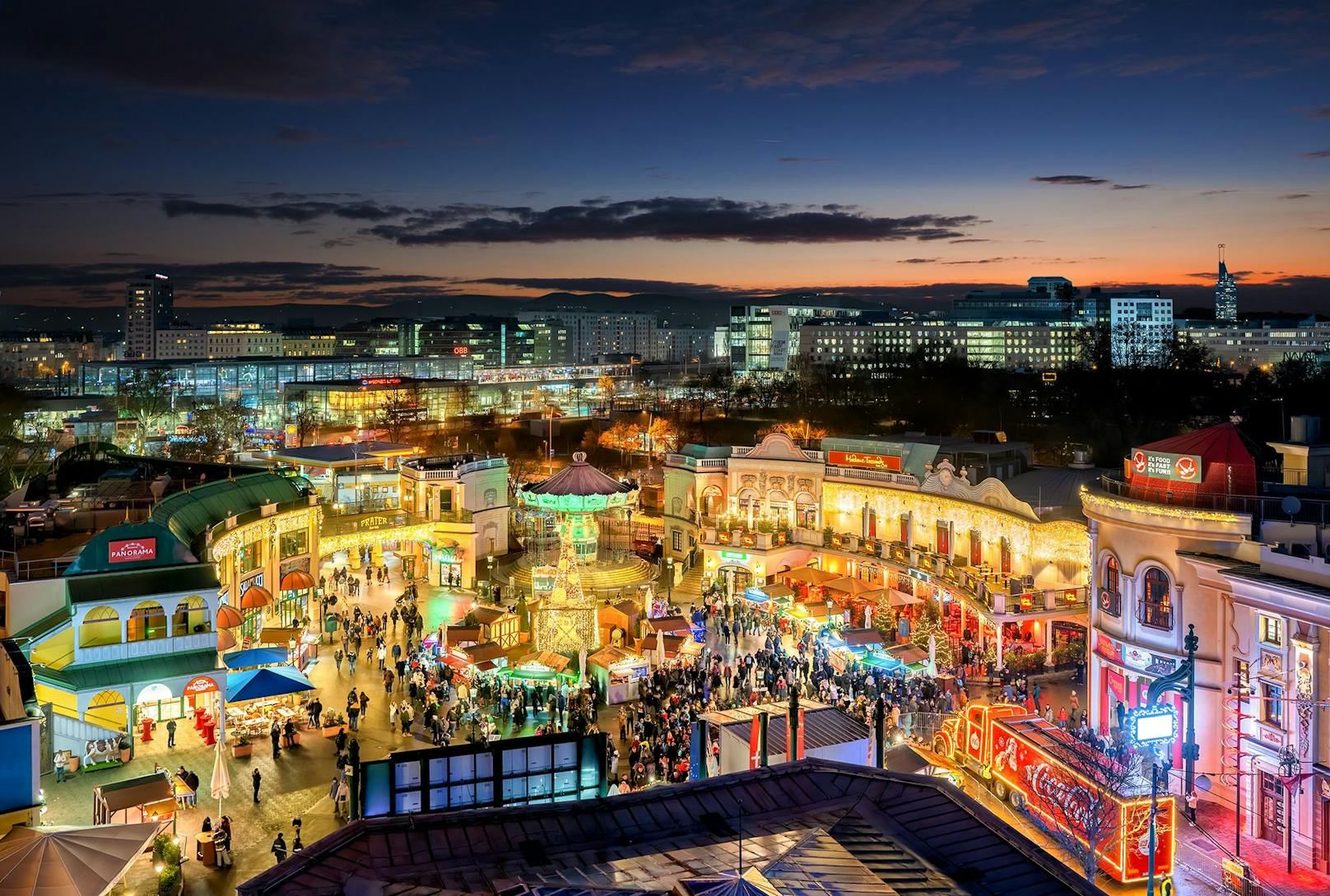 Der Wintermarkt am Riesenradplatz erleuchtet in bunten Farben.