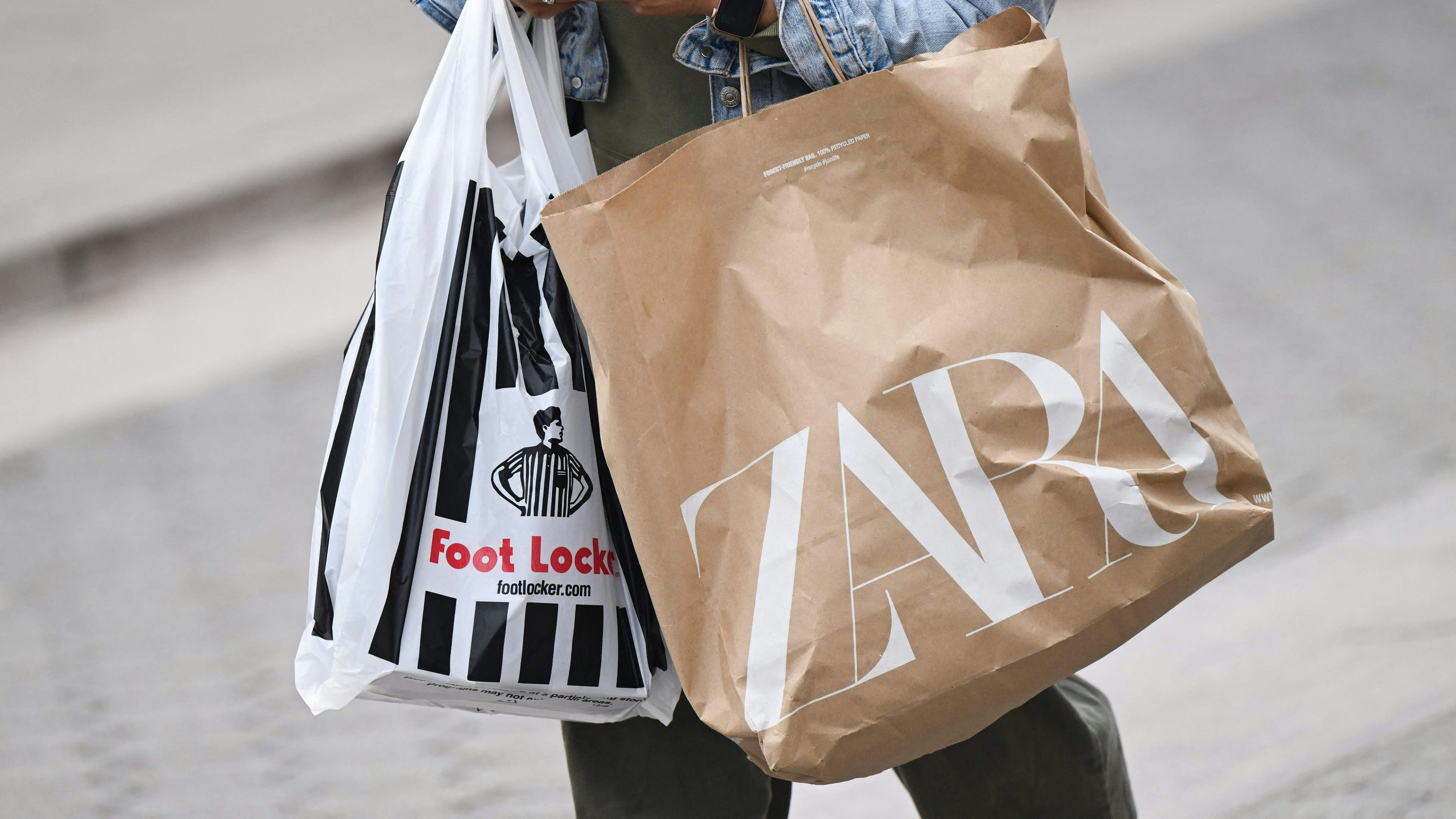 Download von www.picturedesk.com am 17.12.2024 (10:48).  (FILES) A shopper uses an Apple iPhone as they carry Foot Locker and Zara shopping bags while walking down the Third Street Promenade in Santa Monica, California on March 20, 2023. A key indicator of US inflation cooled in June to the lowest annual rate in over two years, although this remains above the central bank's target, according to government data released on July 28, 2023. The Federal Reserve's preferred gauge of inflation, the personal consumption expenditures (PCE) price index, rose 3.0 percent last month from June 2022, down from a 3.8 percent jump in May, said the Commerce Department. (Photo by Patrick T. Fallon / AFP) - 20230320_PD15693 - Rechteinfo: Rights Managed (RM) Nur für redaktionelle Nutzung! Werbliche Nutzung erfordert Freigabe: bitte schicken Sie uns eine Anfrage.