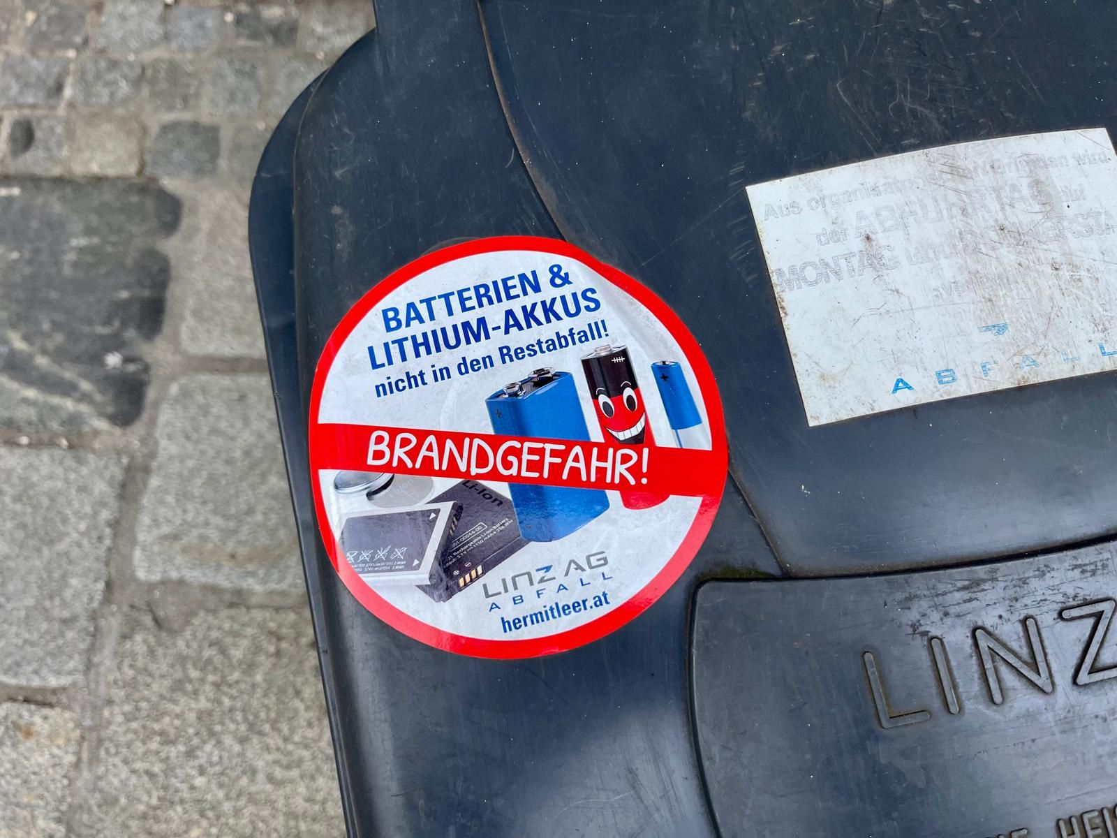 Sticker auf Mülltonnen in Linz warnen jetzt vor einer ungewöhnlichen Gefahr.