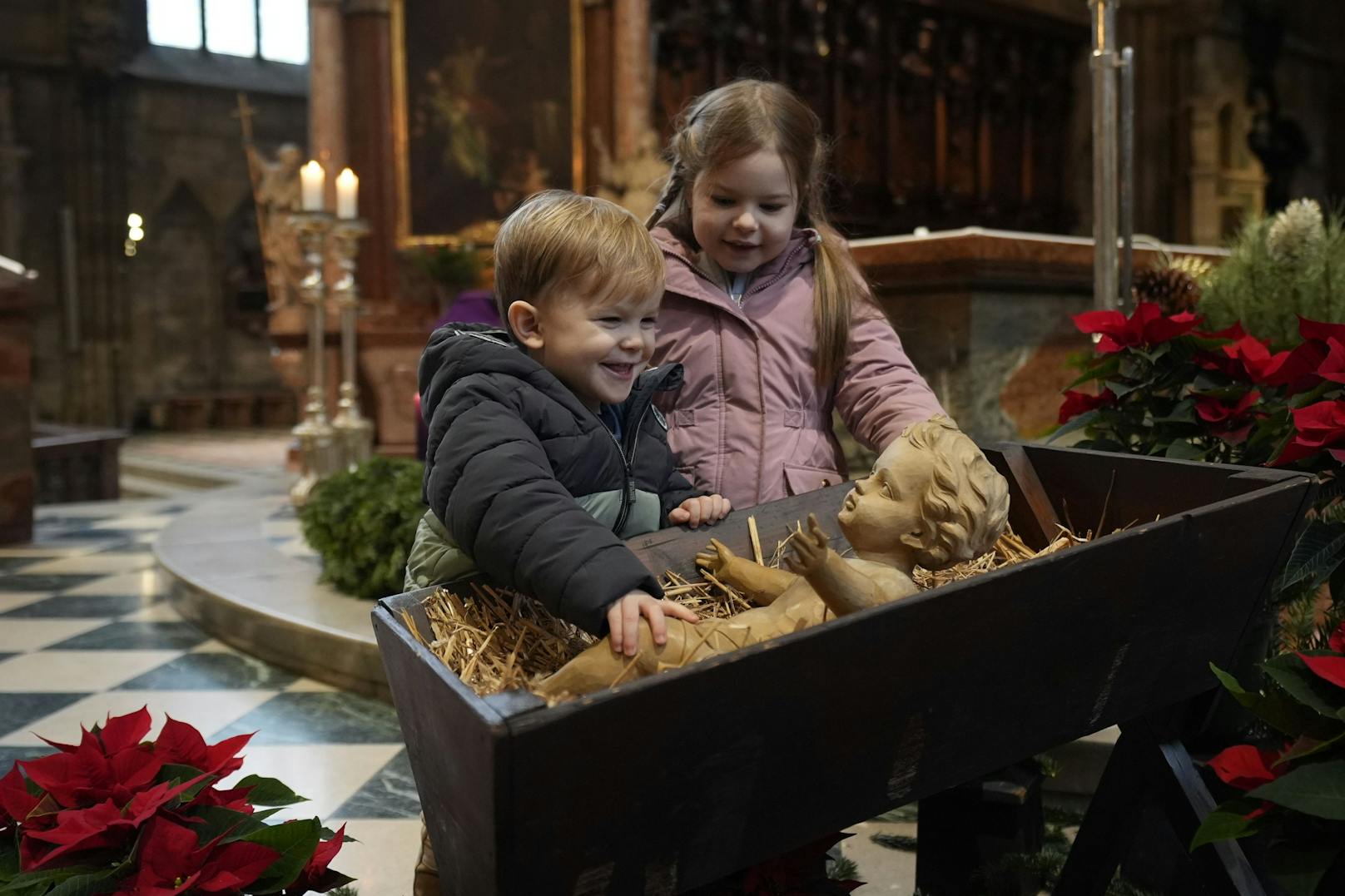 Geschmückt wird die Krippe von Weihnachtssternen.