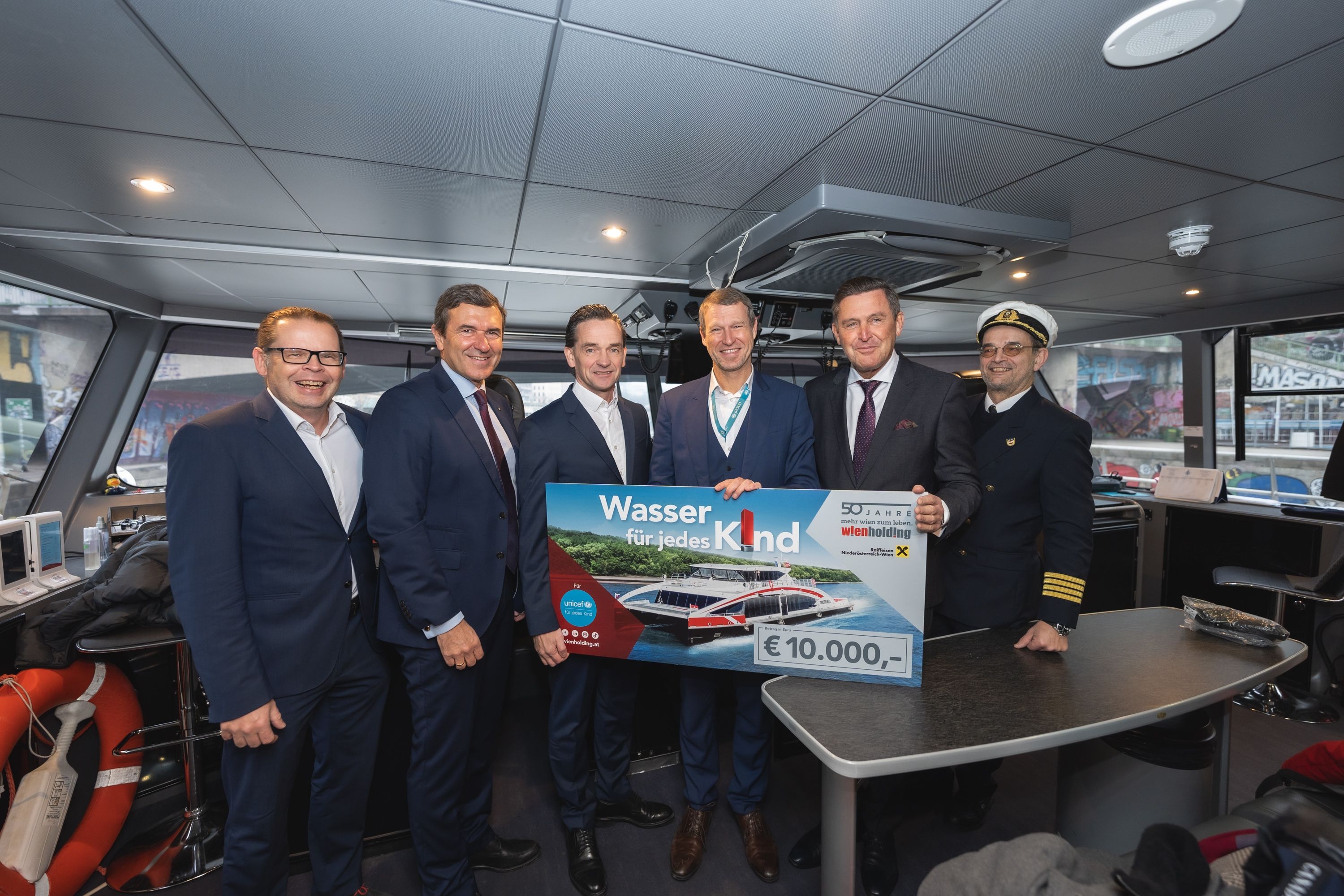 v.l.n.r.: Gerd Krämer (Central Danube-Geschäftsführer), Reinhard Karl (Raiffeisenlandesbank NÖ-Wien), Kurt Gollowitzer (Geschäftsführer Wien Holding), Christoph Jünger (UNICEF Österreich Geschäftsführer), Wirtschaftsstadtrat Peter Hanke und Florian Pausch (Steuermann) bei der Übergabe der Spende