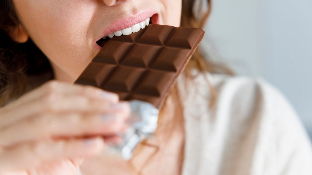 Young woman eating chocolate at home