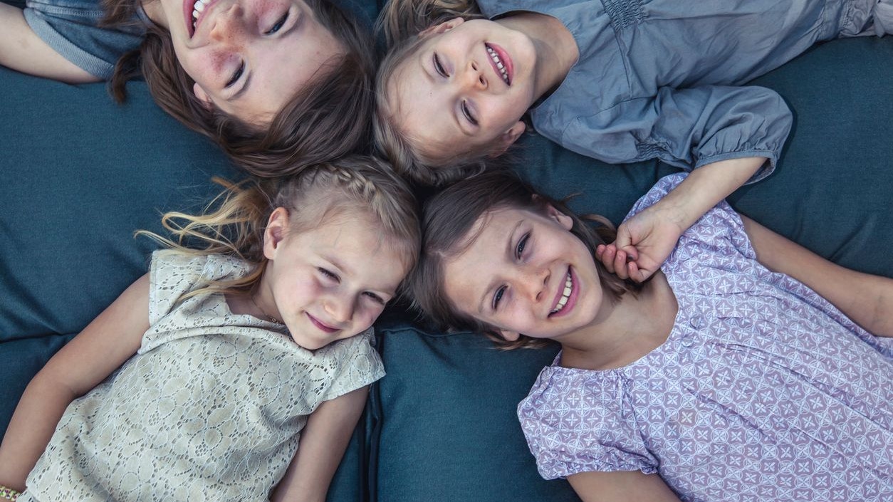 four sisters having fun together and playing out in the garden.