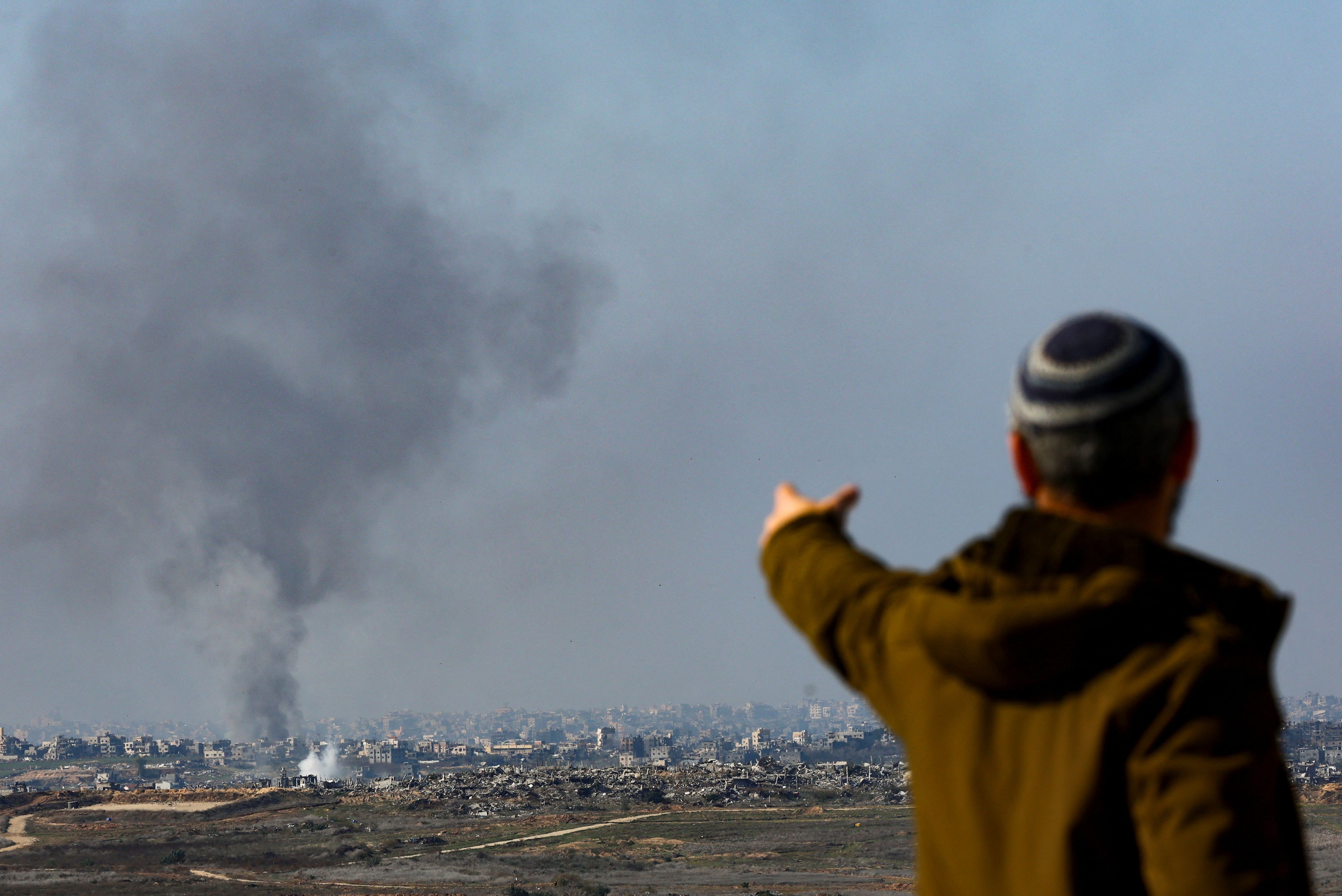 A man gestures as smoke rises from an Israeli strike as the Israeli military conducts operations inside the Gaza Strip, amid the ongoing conflict between Israel and Hamas, as seen from southern Israel, January 2, 2025. REUTERS/Kai Pfaffenbach     TPX IMAGES OF THE DAY     