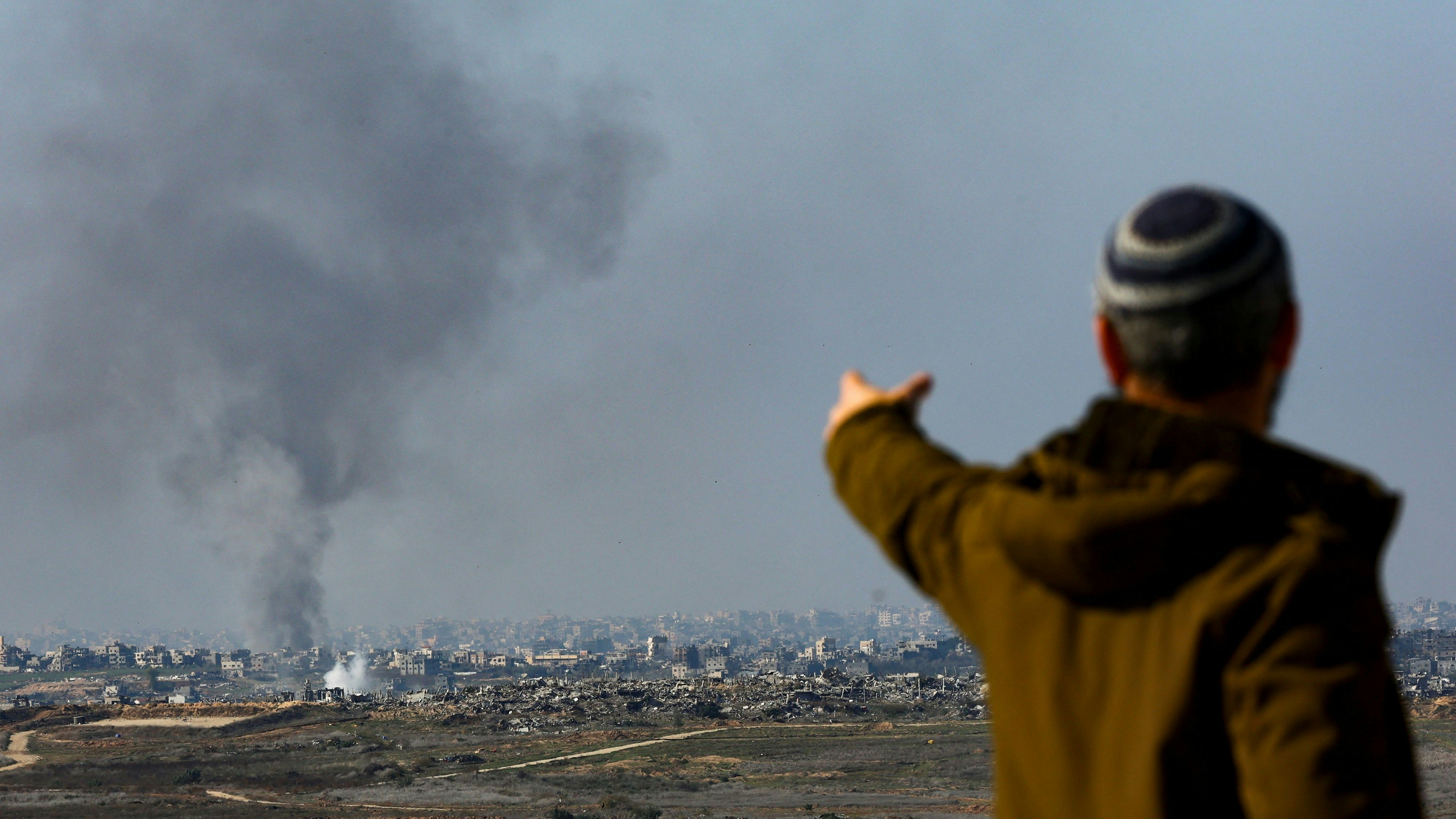 A man gestures as smoke rises from an Israeli strike as the Israeli military conducts operations inside the Gaza Strip, amid the ongoing conflict between Israel and Hamas, as seen from southern Israel, January 2, 2025. REUTERS/Kai Pfaffenbach     TPX IMAGES OF THE DAY     