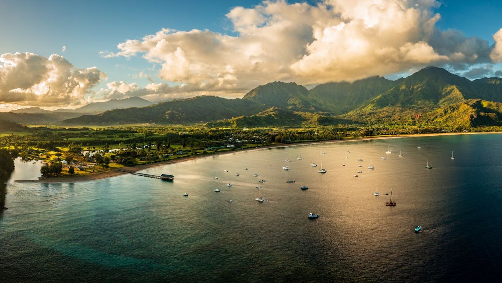 Aerial view of the bay and town of Hanalei with famous pier as the sun rises over the wildlife refuge