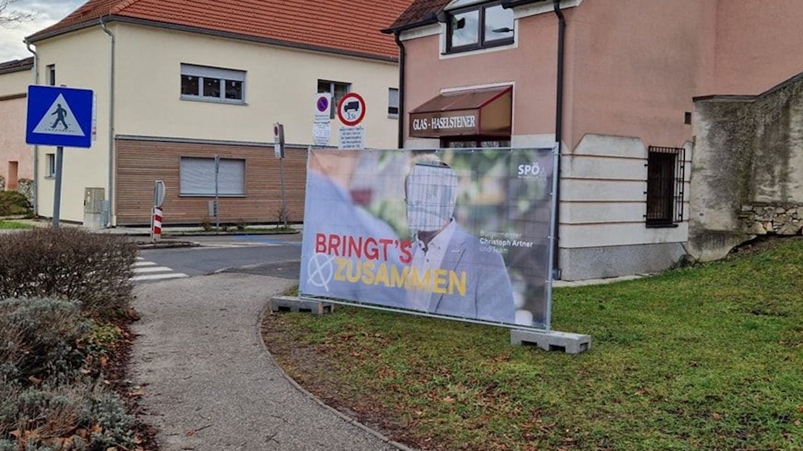 Kopf aus Plakat geschnitten und auf Friedhof platziert