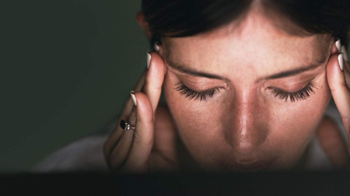 Closeup shot of a young businesswoman looking stressed out while working in an office at night