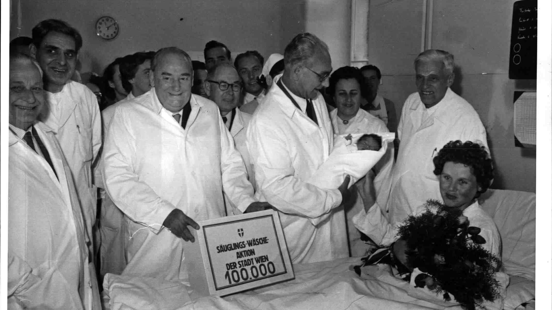 Babystation 1957: Der Wiener Bürgermeister (und spätere Bundespräsident) Franz Jonas übergibt mit Baby am Arm das&nbsp; 100.000 "Säuglingswäsche-Paket". Es galt das Motto: "Kein Wiener Kind darf auf Zeitungspapier geboren werden"