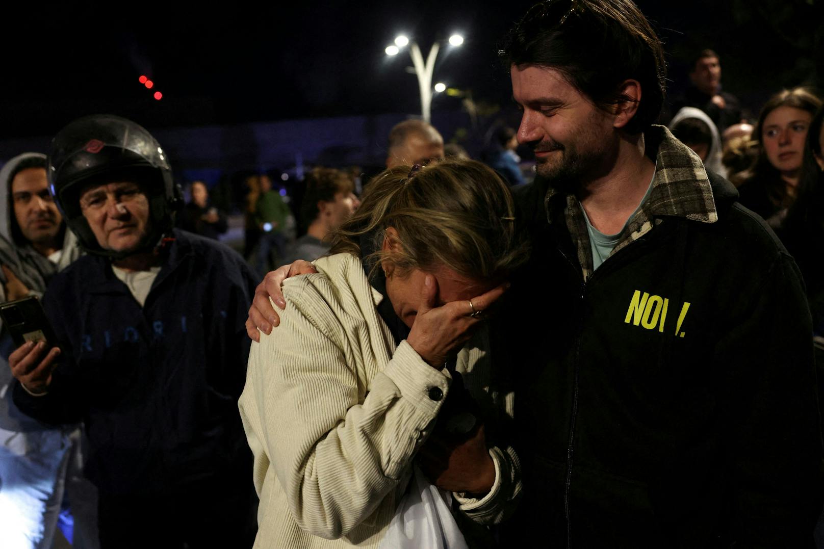 Eine Frau wird emotional als sie auf die Freilassung der drei Geiseln wartet. 