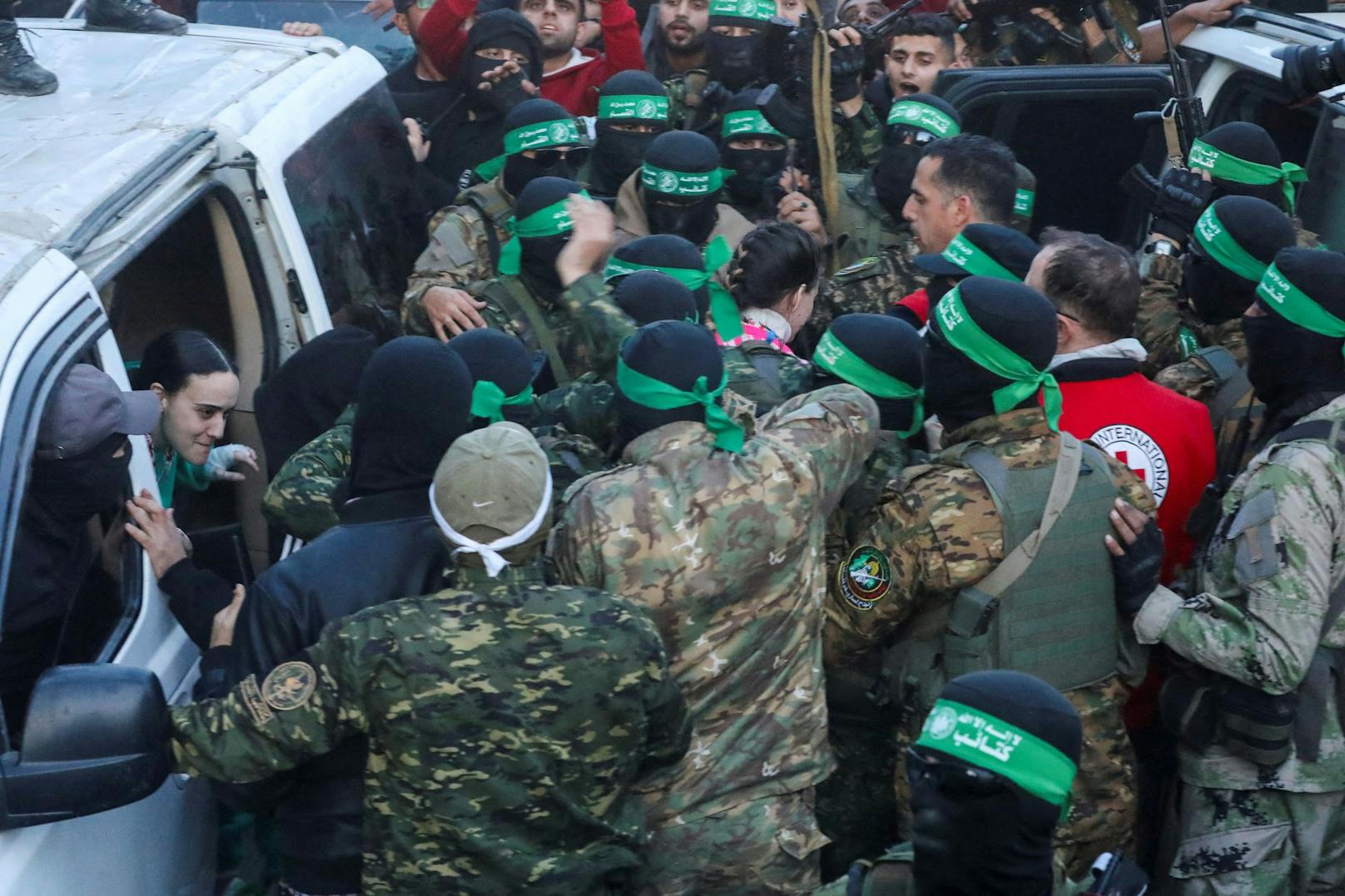 Emily Damari und Doron Steinbrecher werden an das Rote Kreuz übergeben. Sie sind umringt von Hamas-Kämpfer. 