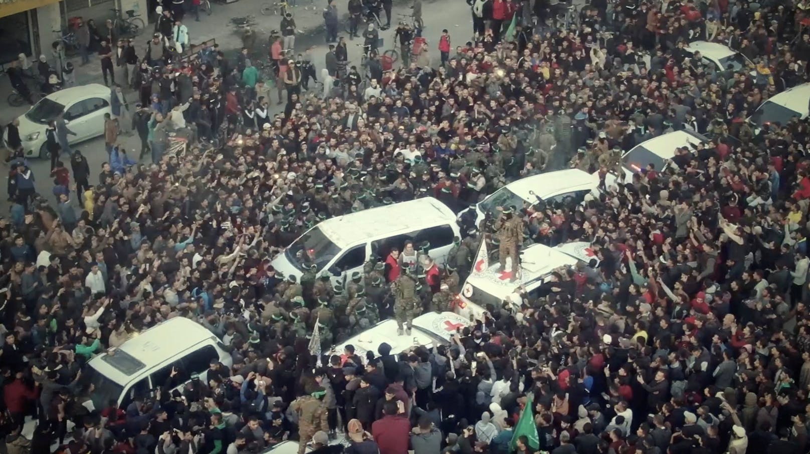 Menschen versammeln sich in der Nähe der Fahrzeuge, als Romi Gonen, Doron Steinbrecher und Emily Damari freigelassen werden