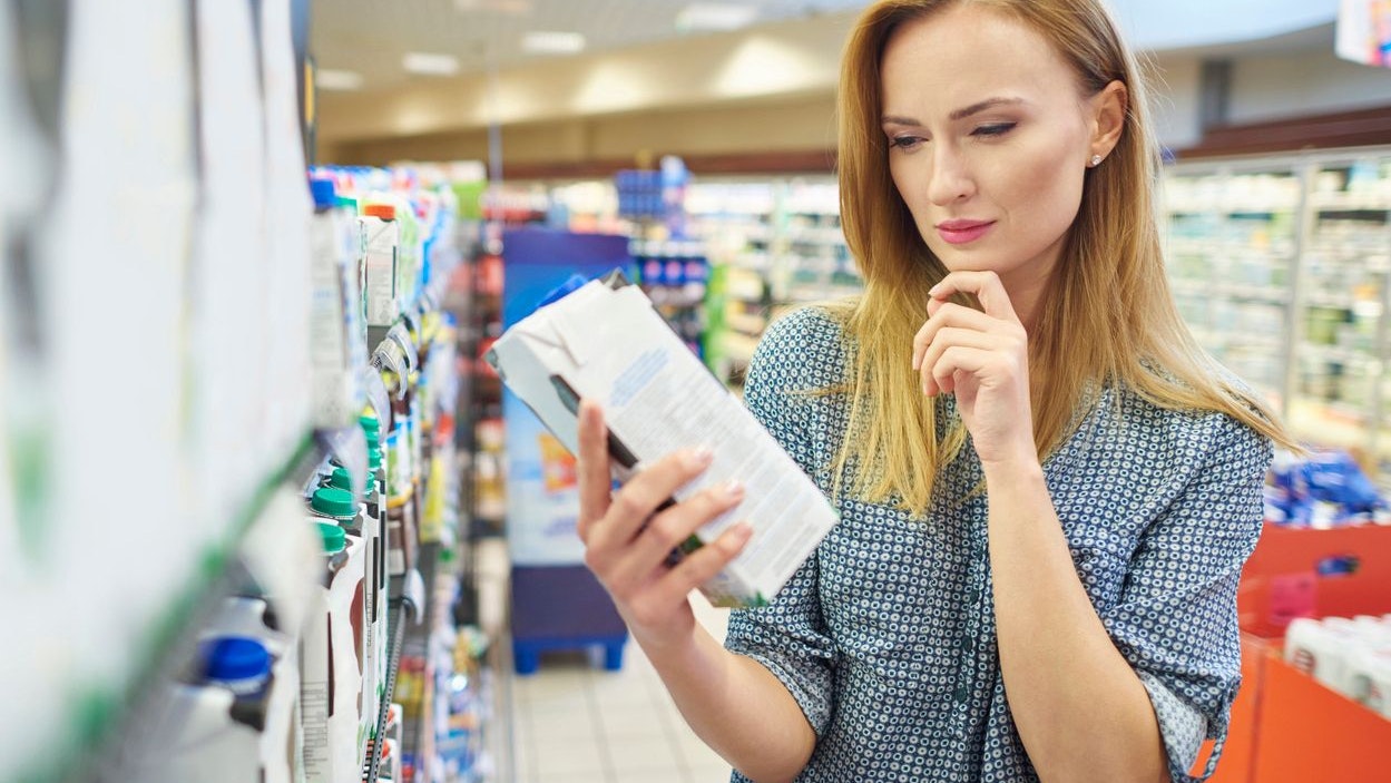 Young woman reading label milk