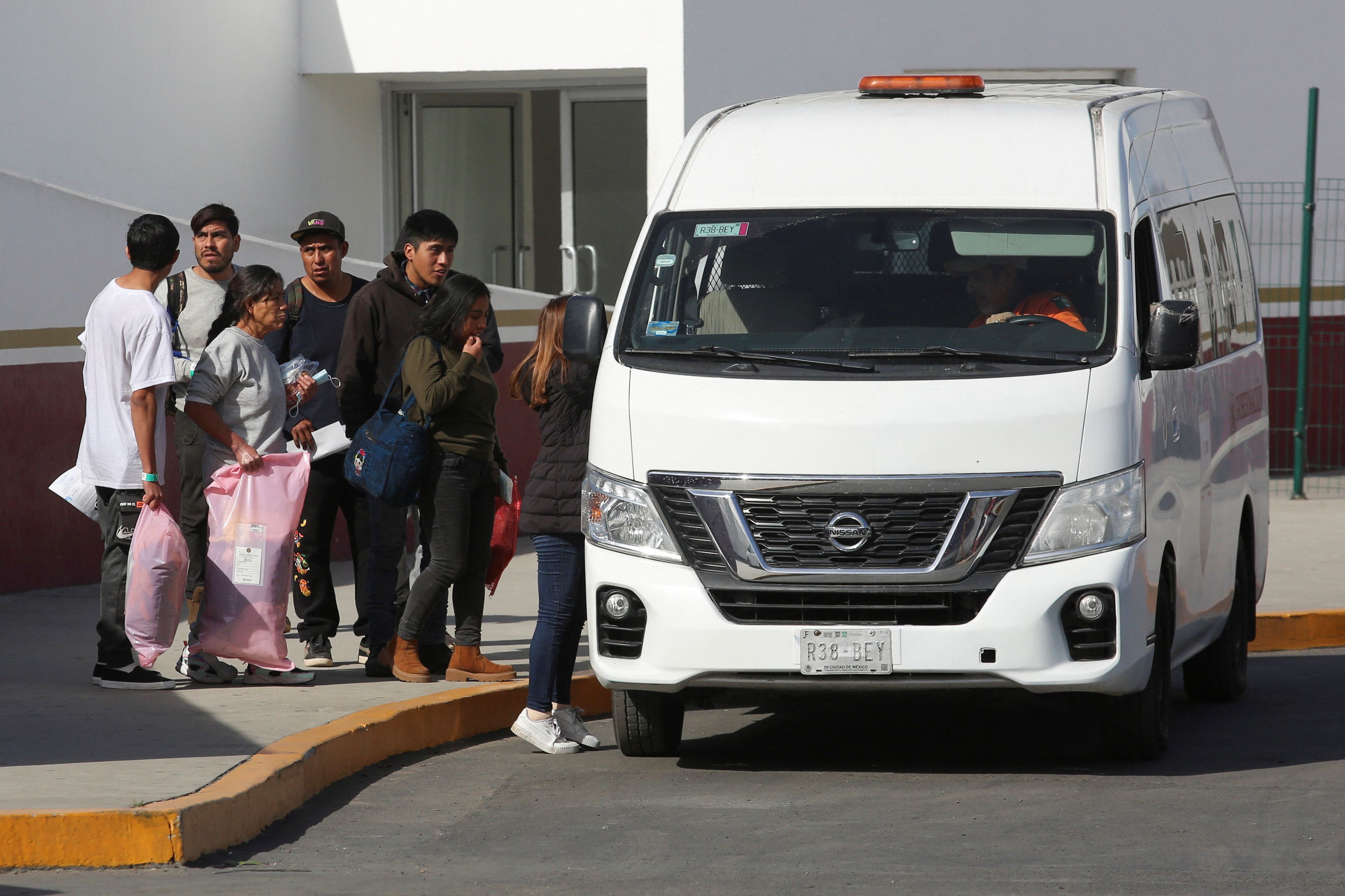 Aus den USA abgeschobene Migranten besteigen am Grenzübergang El Chaparral in Tijuana, Mexiko, einen Lieferwagen des mexikanischen Nationalen Migrationsinstituts.