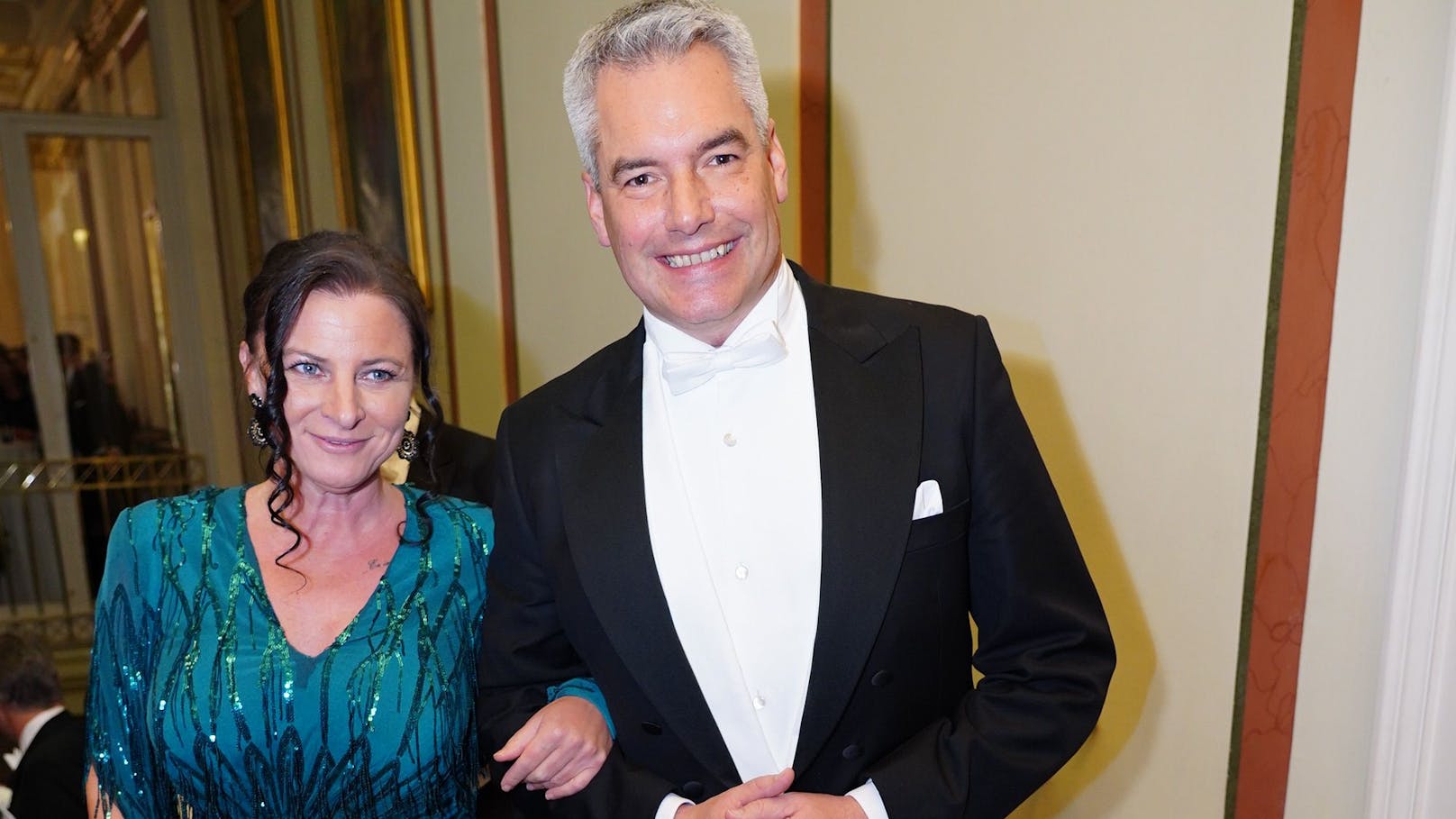 Karl Nehammer mit Ehefrau Katharina Nehammer in einem Paillettenkleid in "forest green" von Designer Atil Kutoglu am Philharmonikerball 2025.