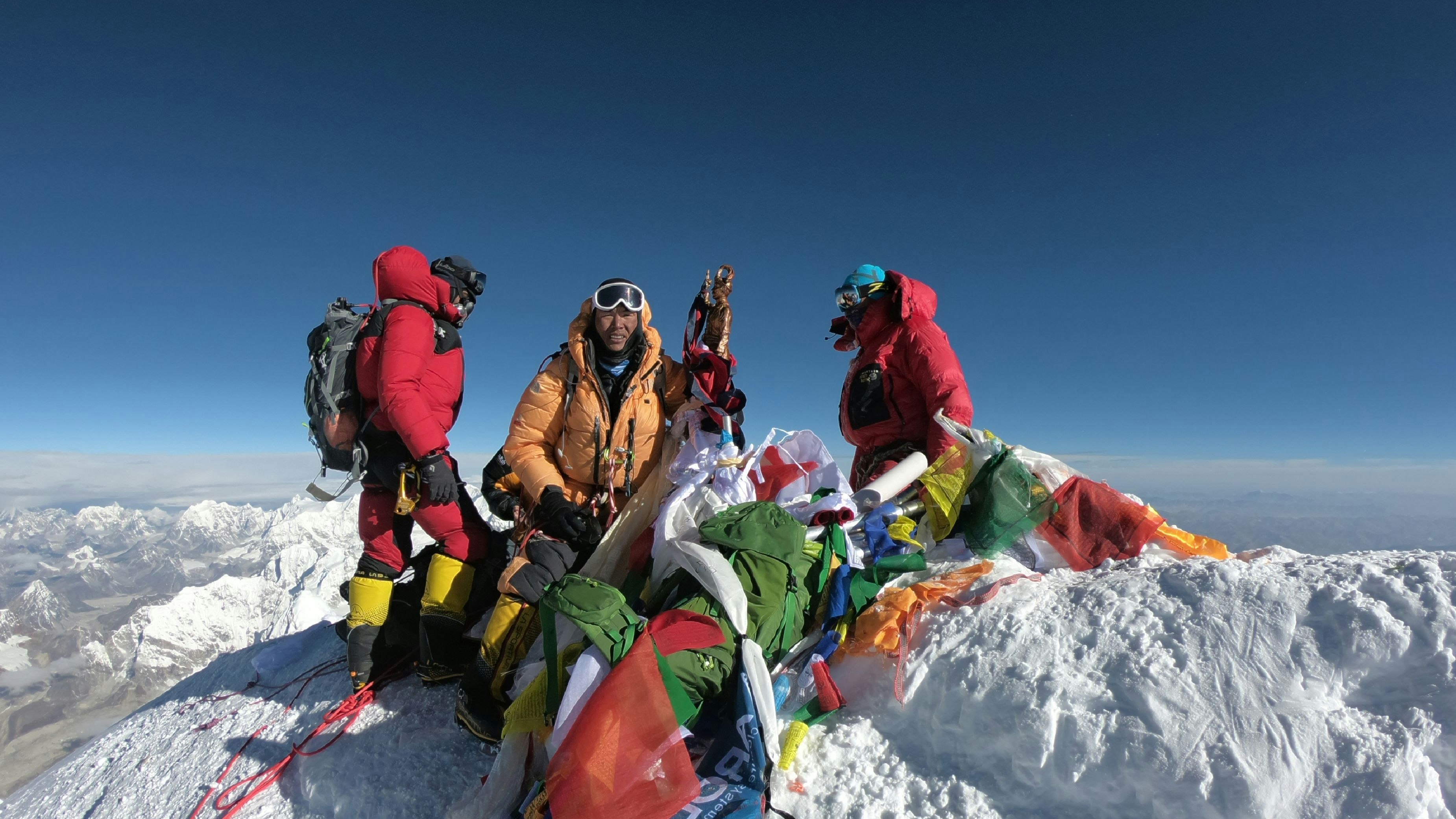 Eine Bergsteigergruppe und ihr Sherpa am mit 8.848 Metern höchsten Gipfel der Welt