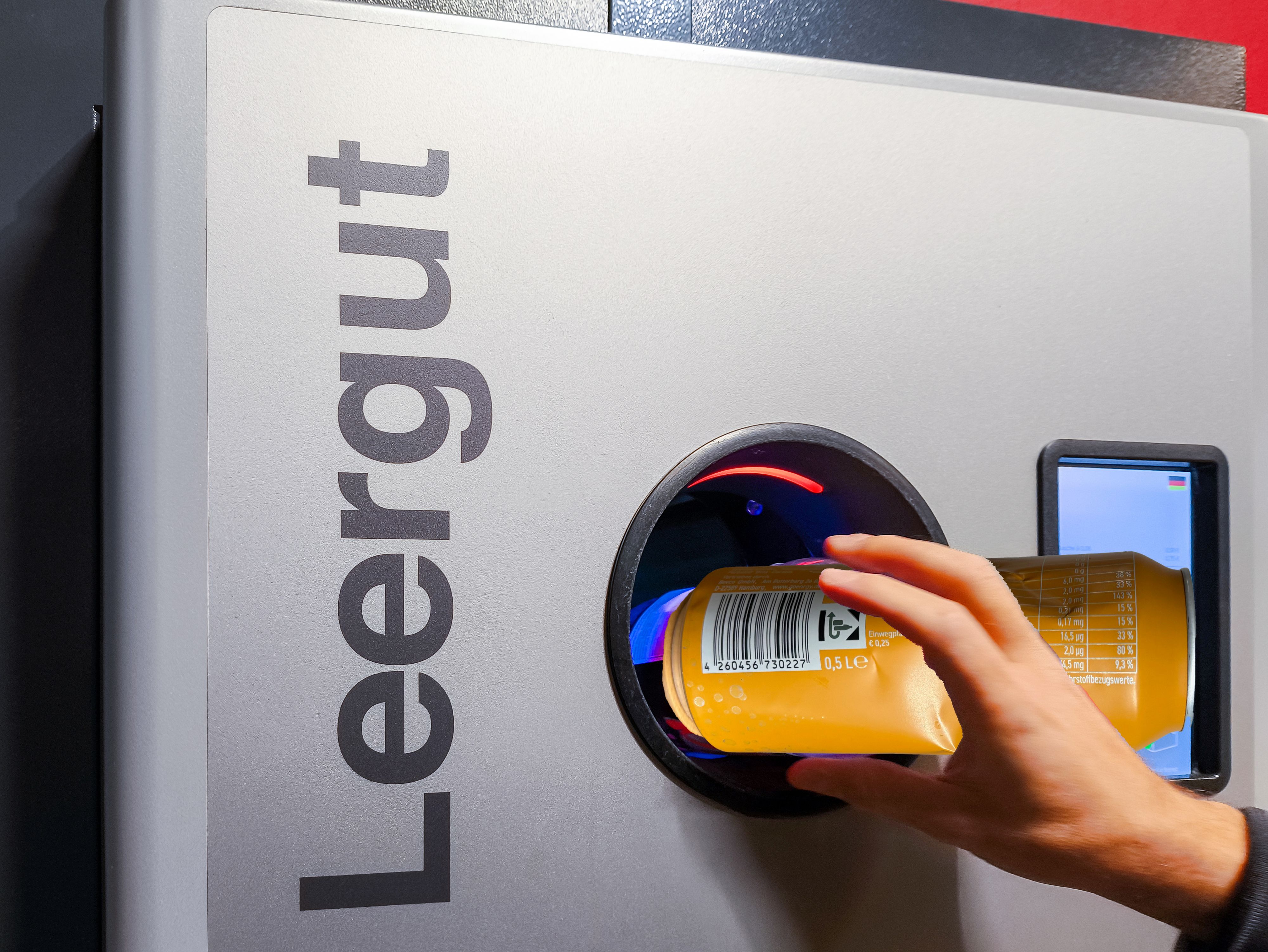 Ein Kunde versucht, eine Dose mit deutschem Pfandlogo in einem Wiener Supermarkt zurückzugeben – doch der Automat verweigert die Annahme. Unterschiedliche Pfandsysteme sorgen für Verwirrung.