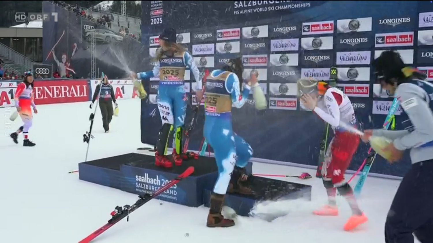 Katharina Truppe sprüht sich selbst Champagner ins Gesicht, lässt die Flasche in den Schnee fallen.