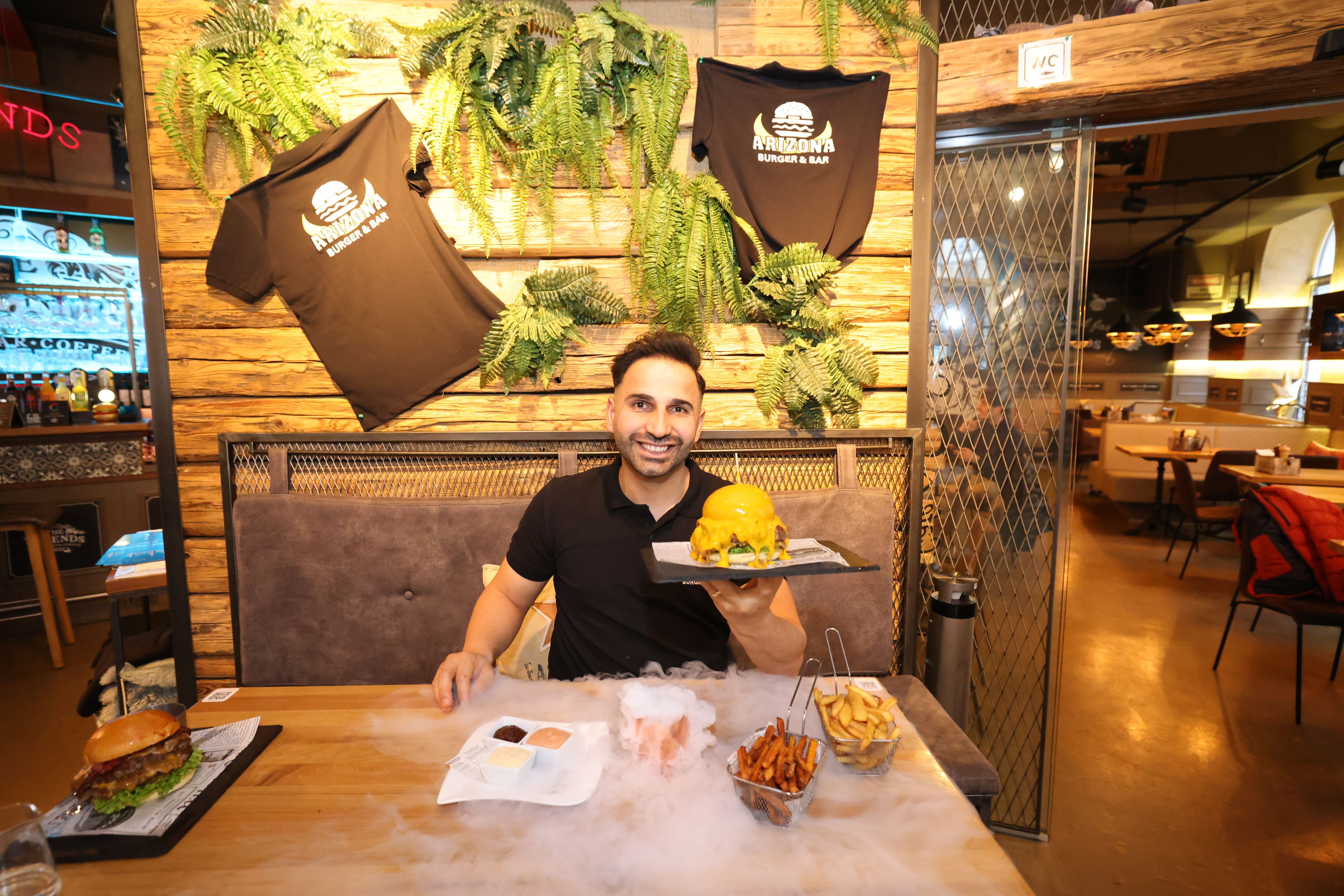 Ali, der Betreiber des Arizona Burger & Bar, präsentiert den berühmten Cheddar-Burger – flüssiger Käse, dampfendes Trockeneis und XXL-Genuss!