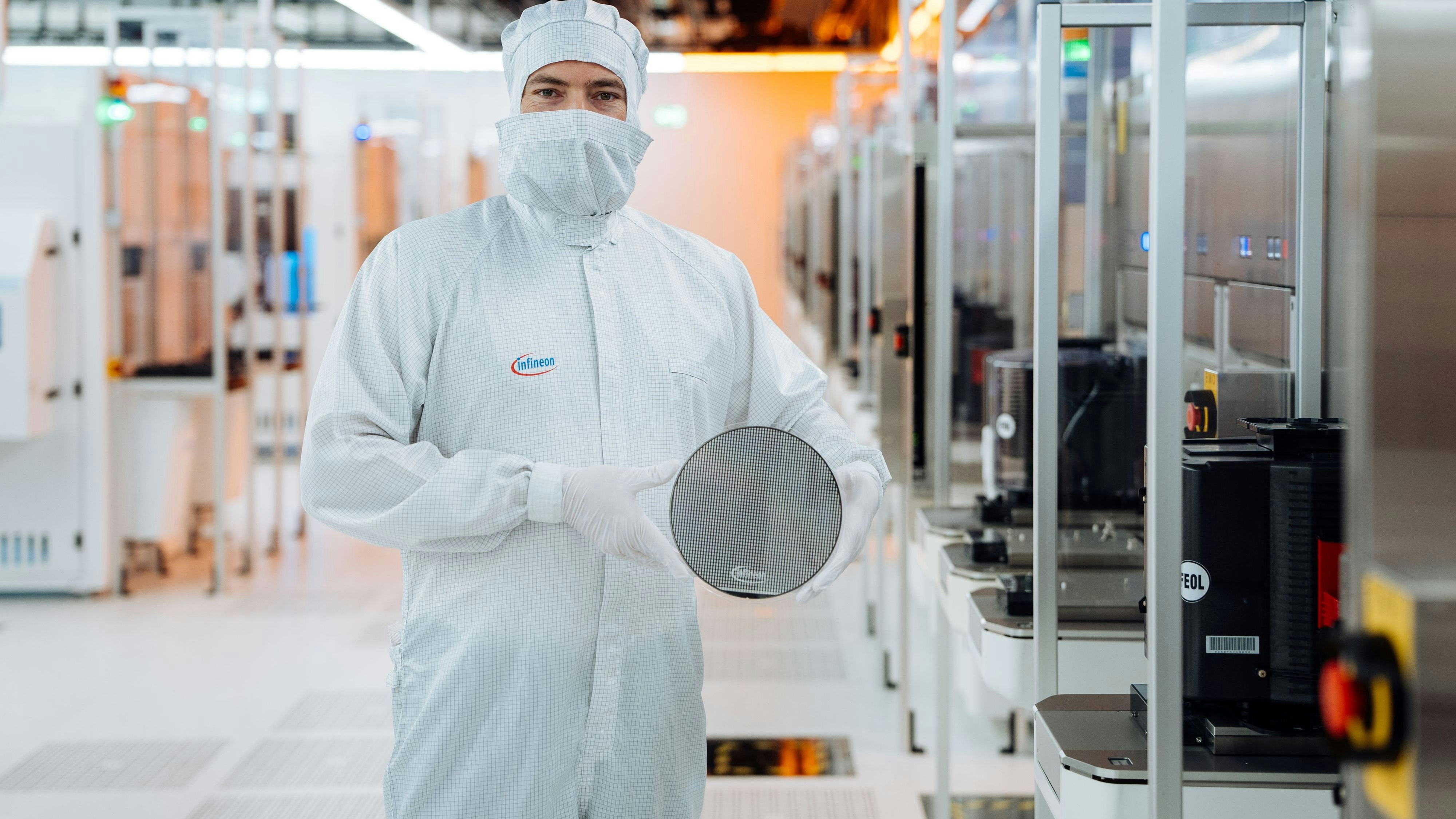 Ein Techniker im Reinraum von Infineon Technologies in Villach, Österreich, hält einen 200 mm Siliziumkarbid-Wafer. 