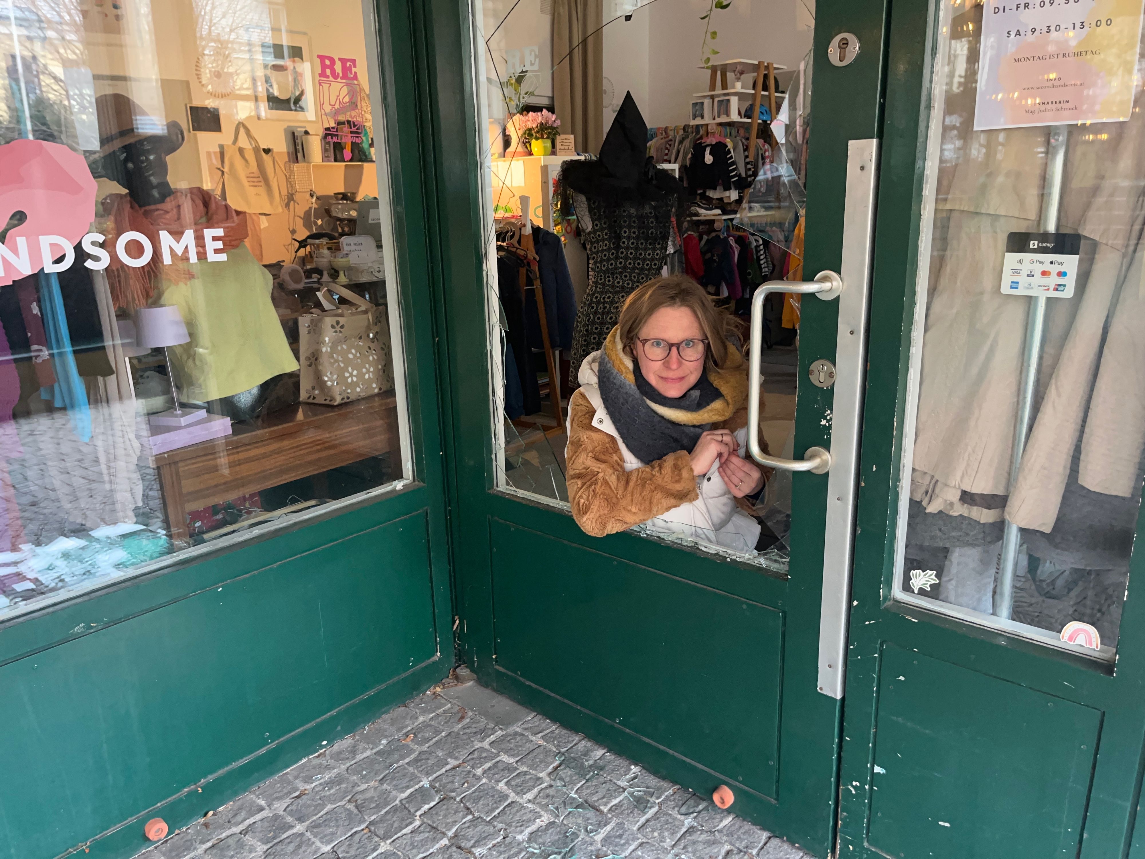Judith Schmuck hinter der zertrümmerten Tür ihres Geschäfts.