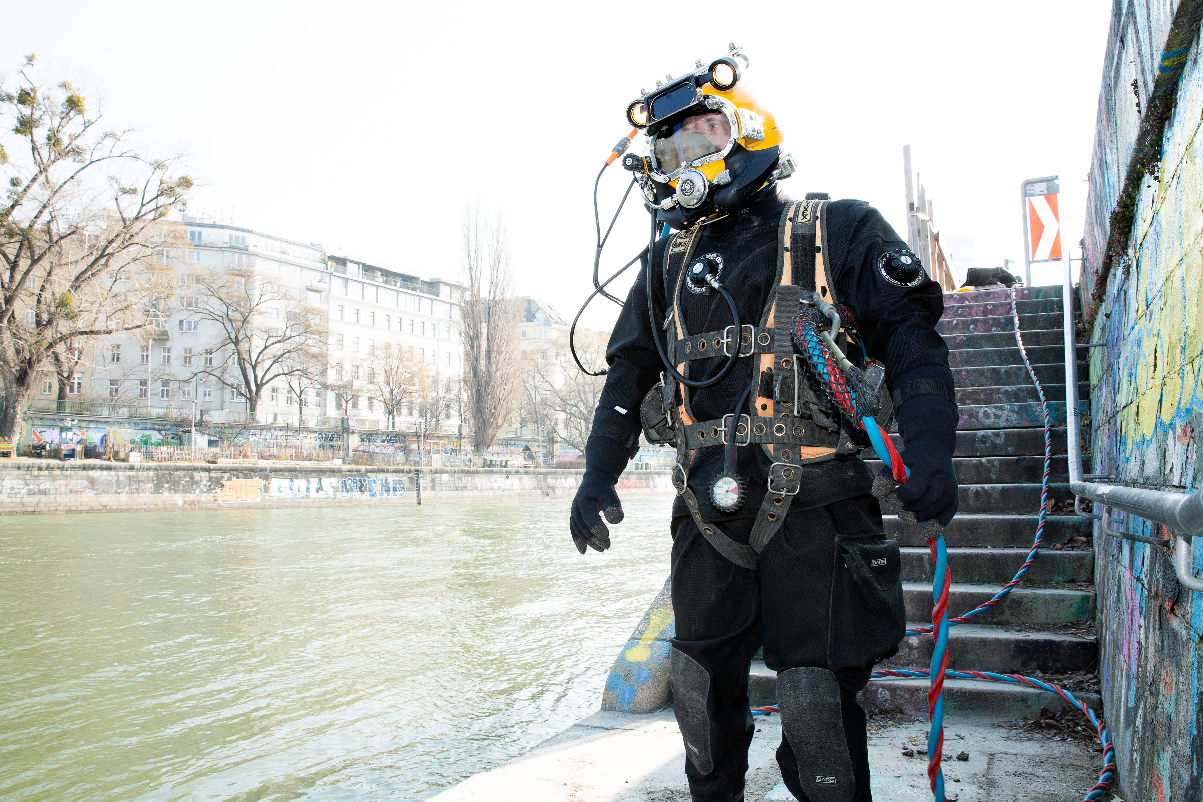 Ein Industrietaucher im Einsatz am Donaukanal: Bei eiskalten Temperaturen führt er Wartungsarbeiten an den Einlaufbauwerken der Wiener Fernkälte durch.