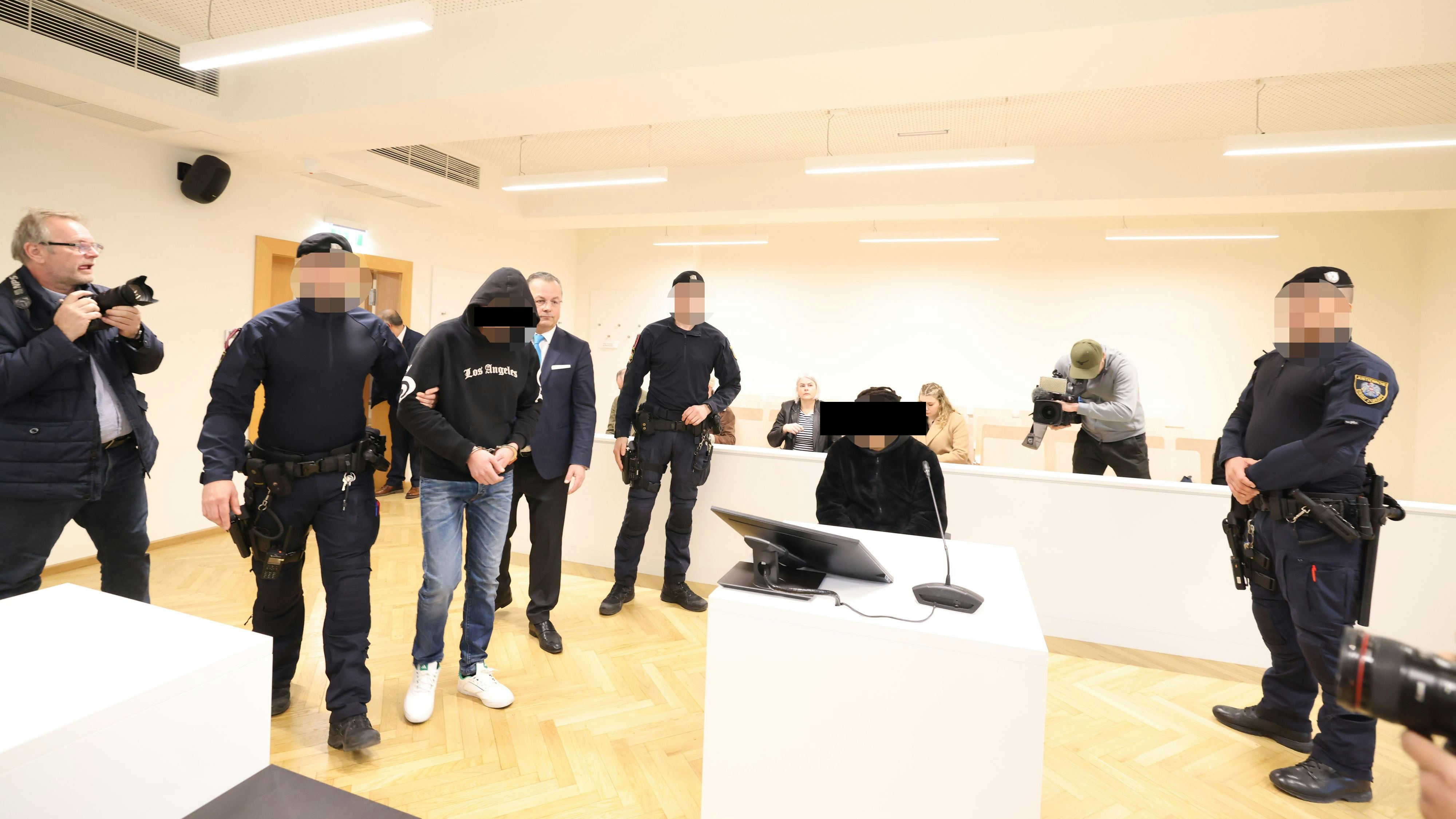 Die beiden Angeklagten im Gerichtsaal - sie werden streng bewacht.