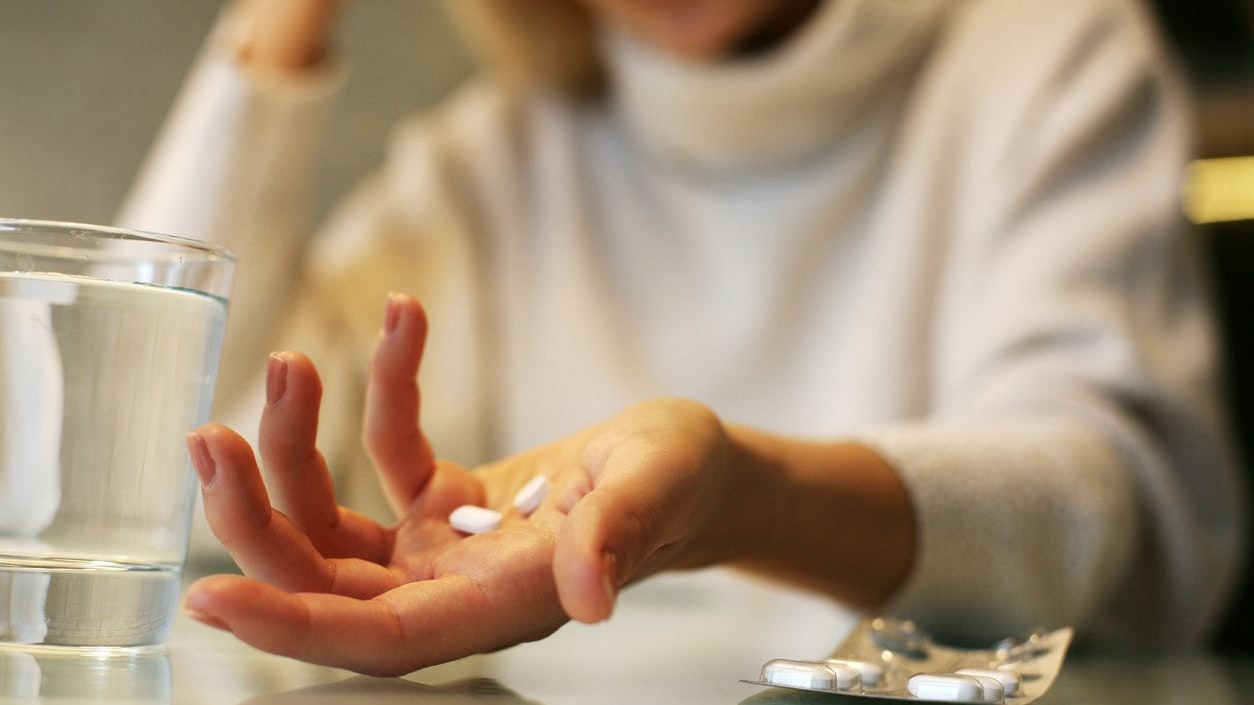 Close up of woman hands holding a pills.