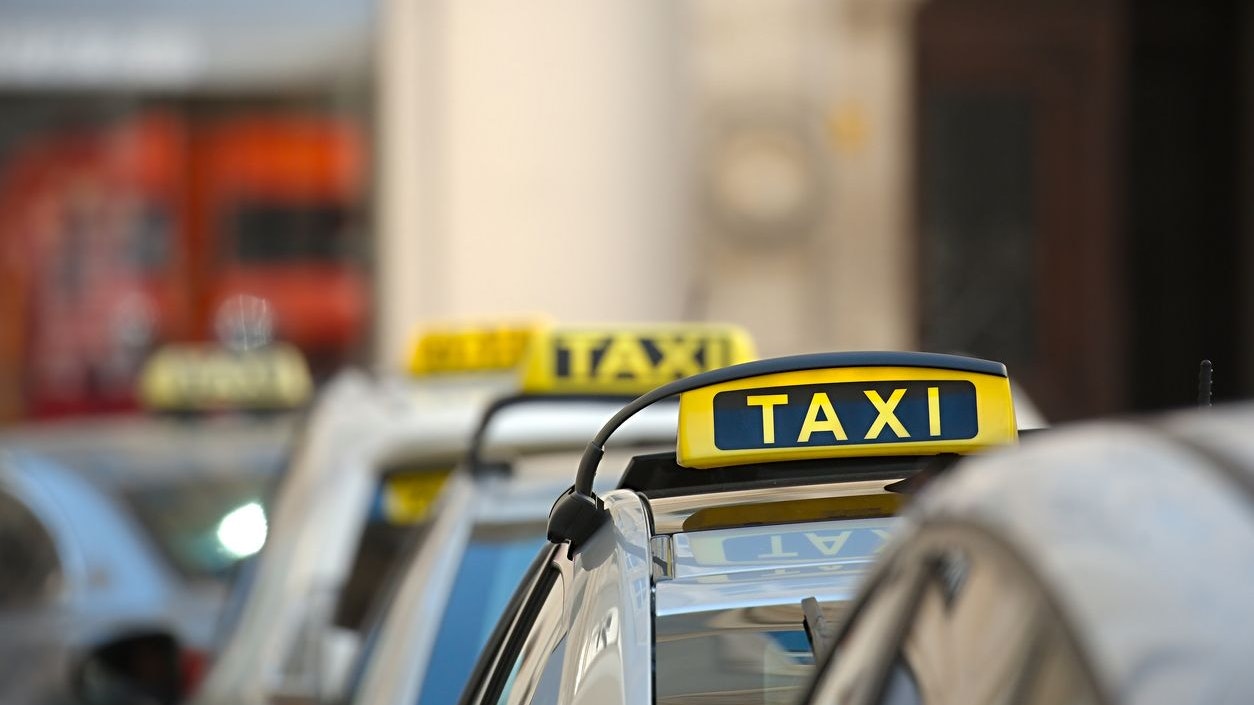 Taxis on a street with yellow signs
