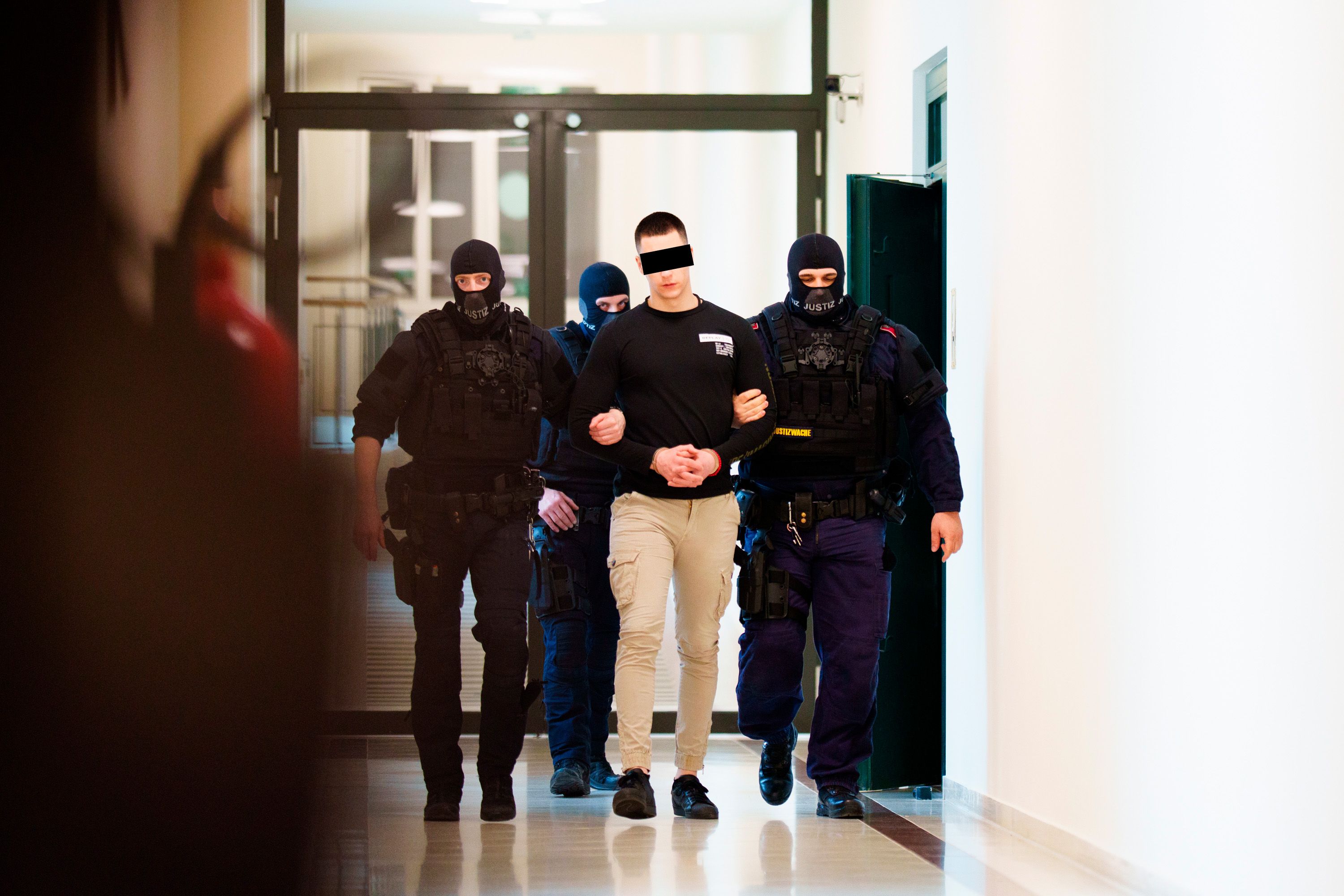 Der großgewachsene Angeklagte in Handschellen vor Gericht.