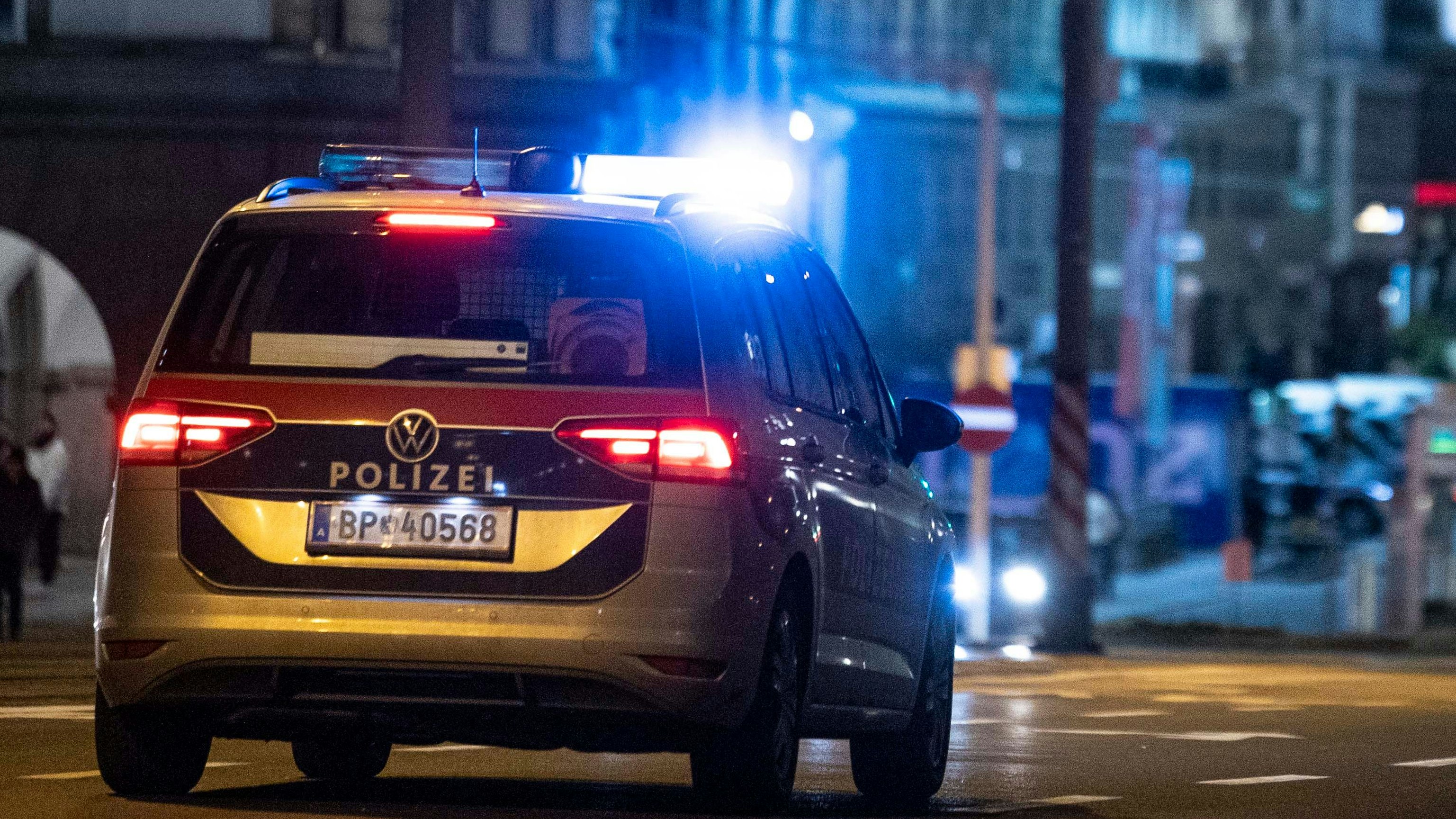 Ein Polizeiauto mit Blaulicht während eines nächtlichen Einsatzes.