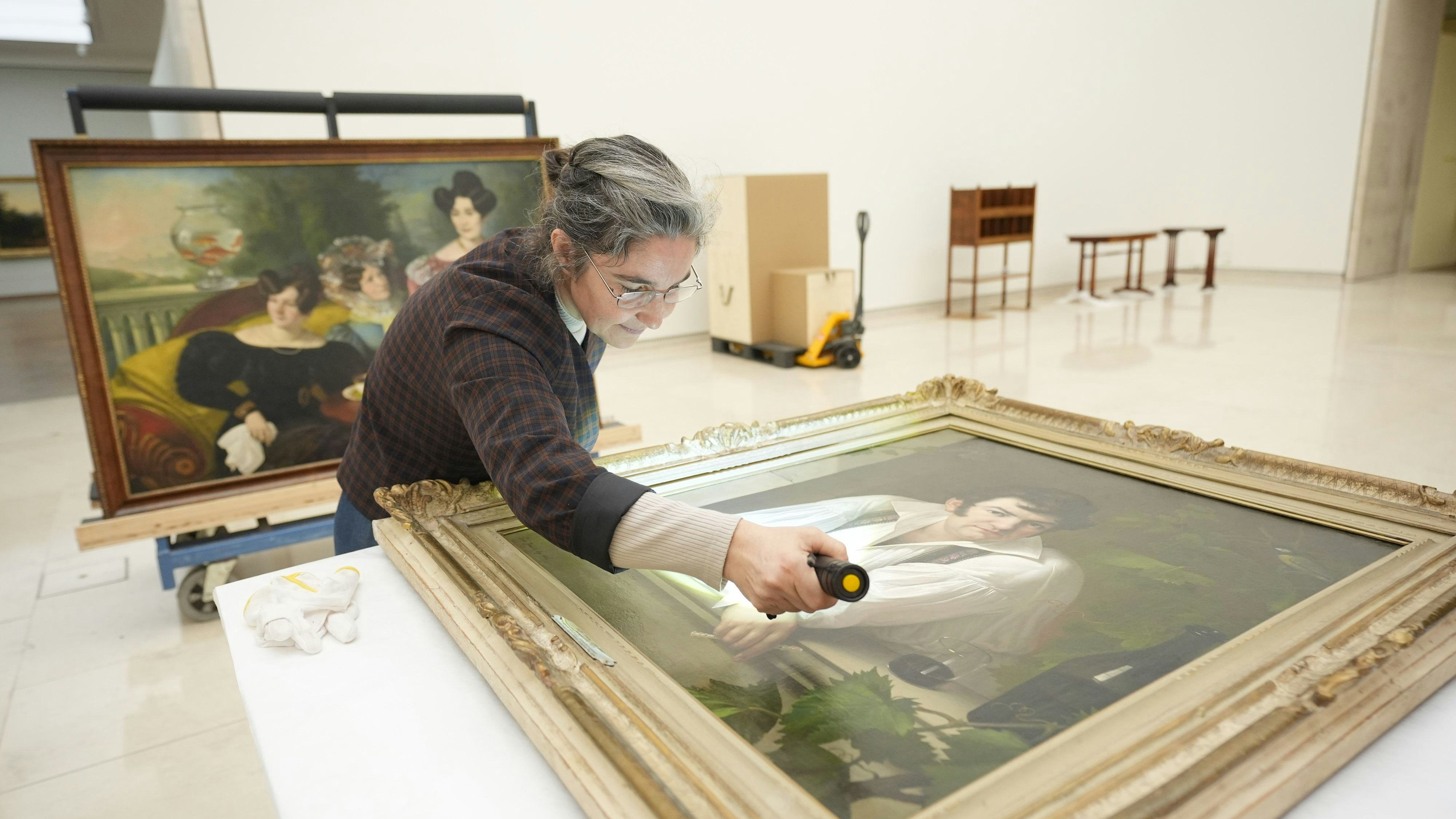 Bevor "Selbstporträt am Fenster" von Jozef Tomnic (1826) aufgehängt wird, beleuchtet eine Mitarbeiterin des Leopold Museums das Werk und prüft auf etwaige Fehler.