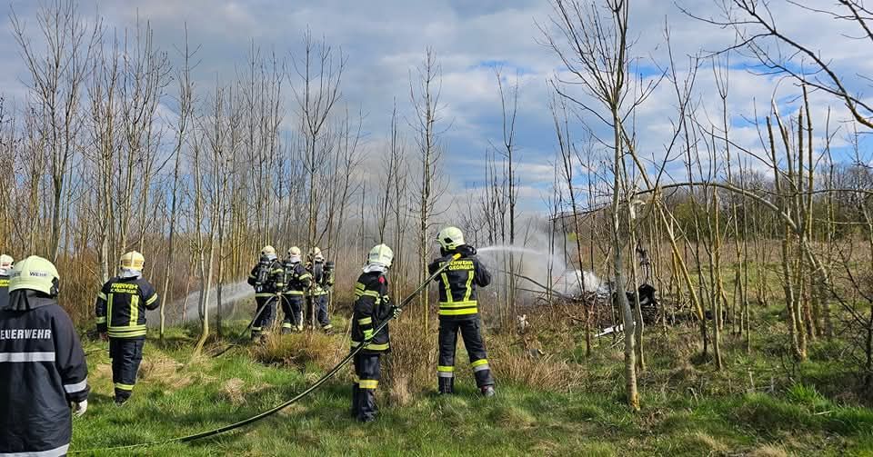 Hier löschen Feuerwehrleute das brennende Wrack.