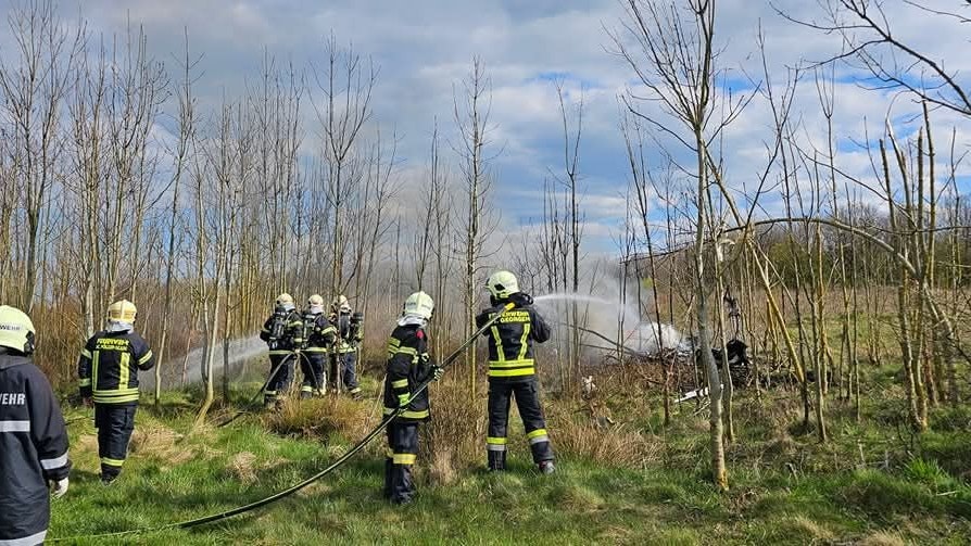 Hier löschen Feuerwehrleute das brennende Wrack. 
