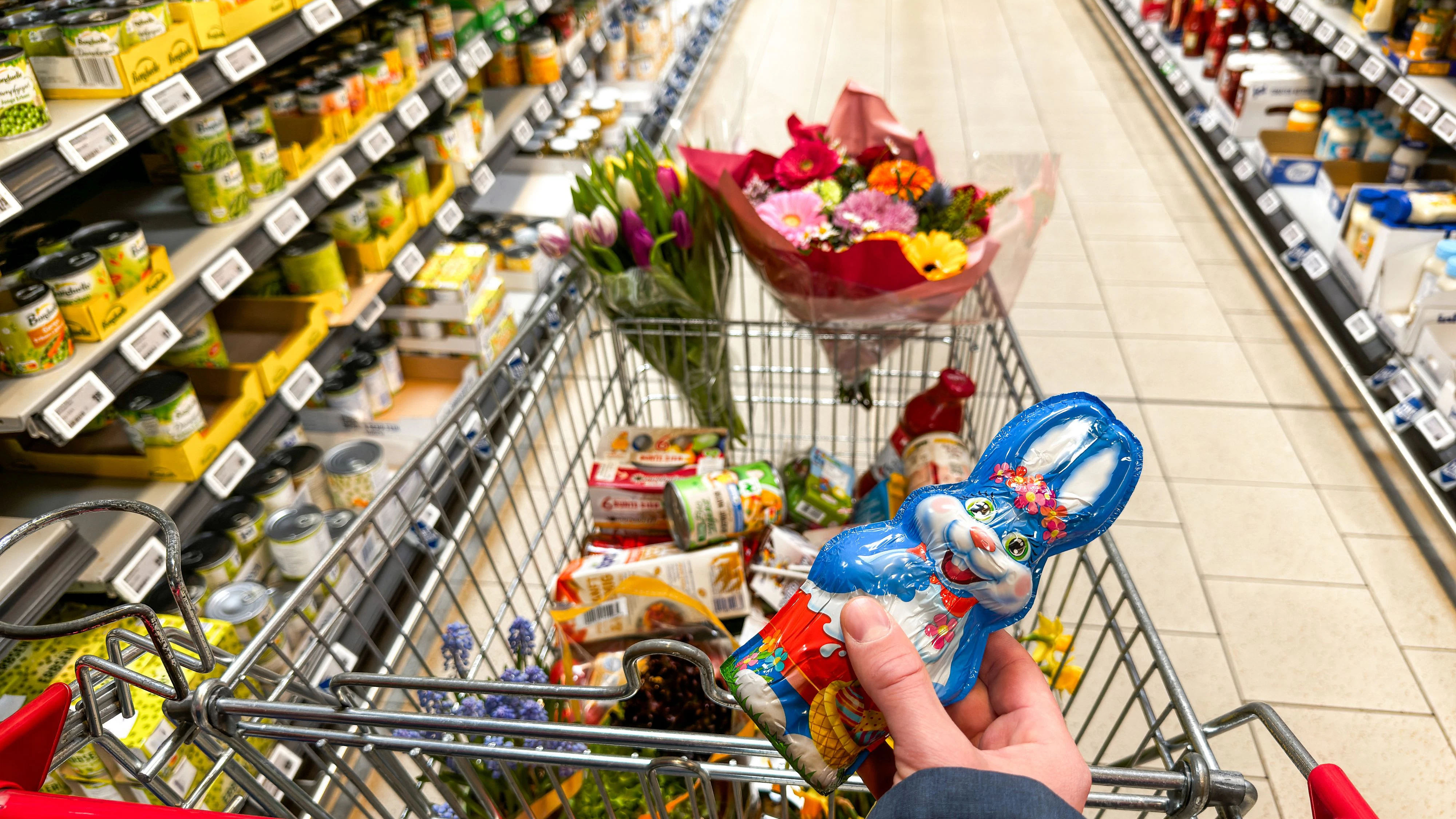 Download von www.picturedesk.com am 15.04.2025 (12:23).  Ein voller Einkaufswagen mit Blumen und Schokohase zeigt die typischen Vorbereitungen für Ostern - vom festlichen Essen bis zu kleinen Geschenken und Dekorationen für das Frühlingsfest. - 20250402_PD20695 - Rechteinfo: Rights Managed (RM) Nur fÃ¼r redaktionelle Nutzung!