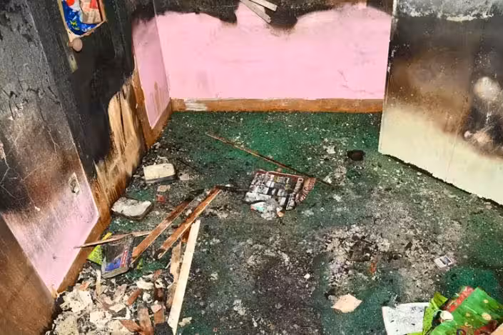 Fotos des Hauses zeigen verwahrloste Räume mit verrußten Wänden, beschädigten Böden und Türen, die von außen verriegelt waren.