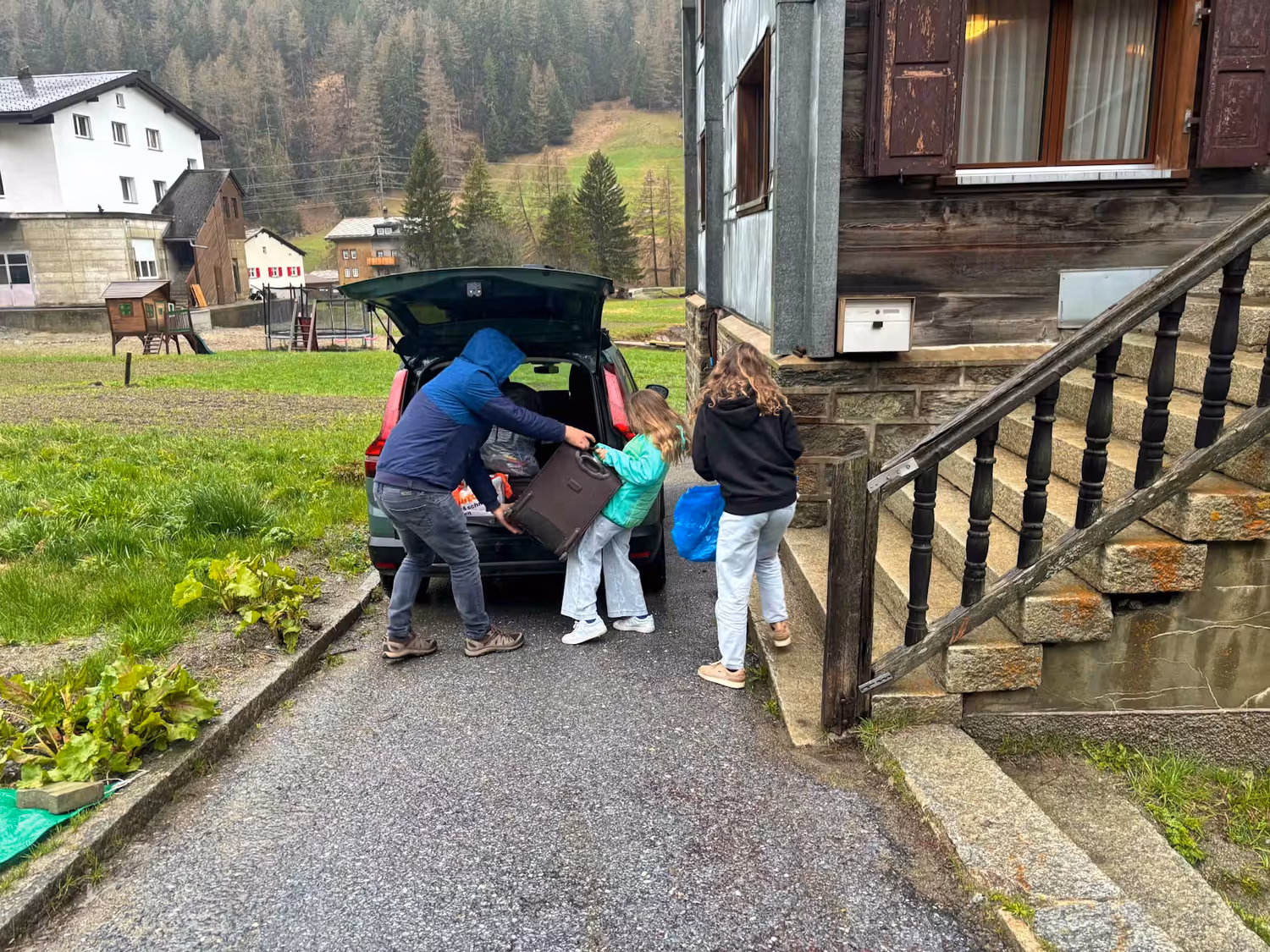 Die Familie packt schleunigst ihr Gepäck ins Auto.