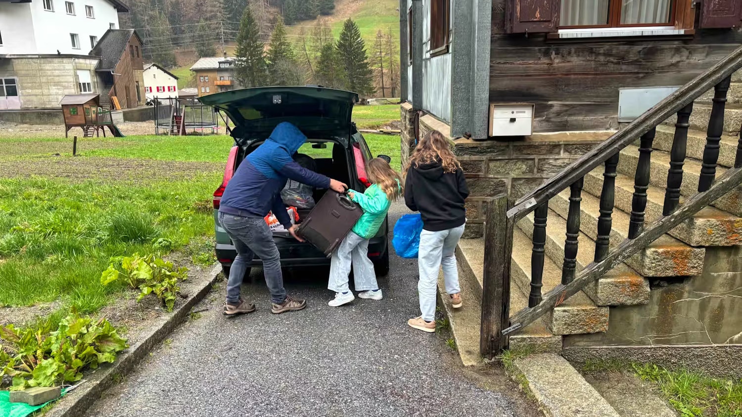 Die Familie packt schleunigst ihr Gepäck ins Auto.
