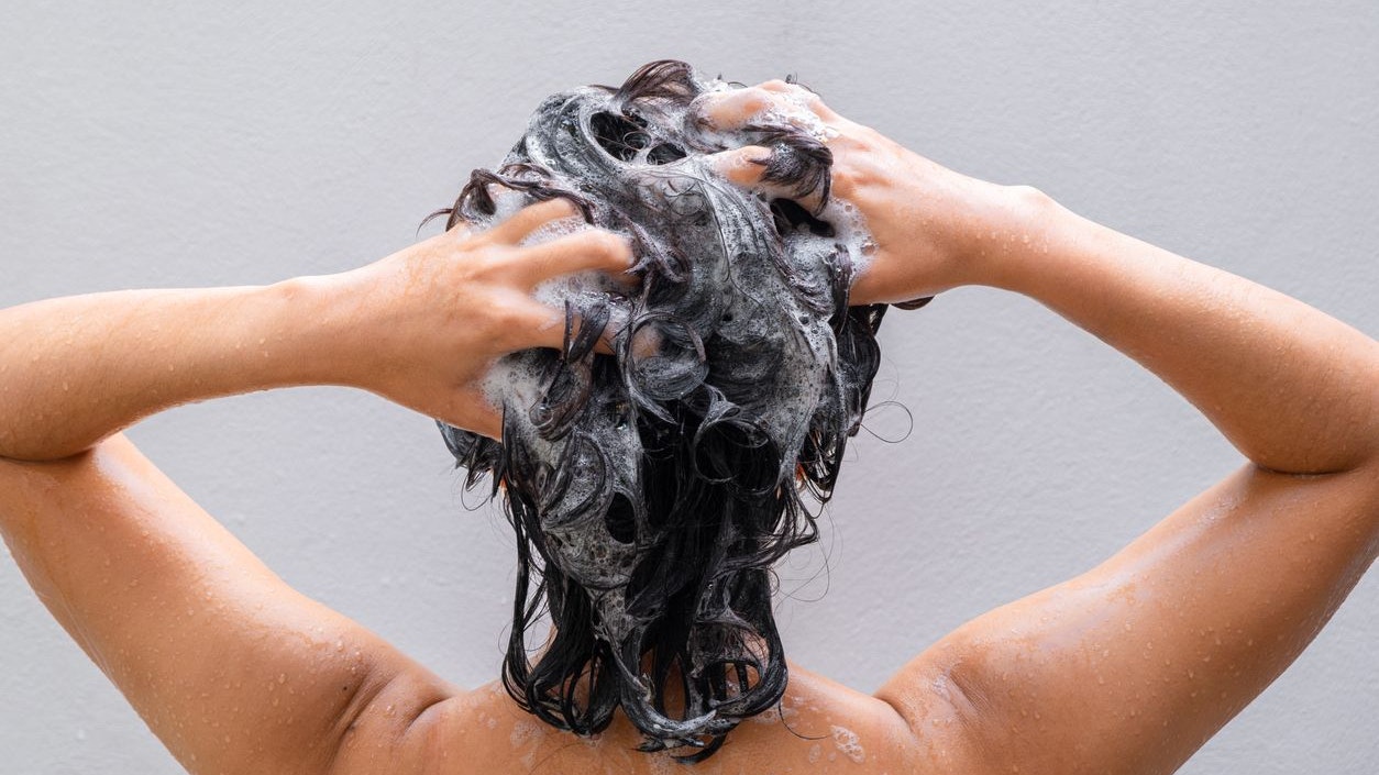 Beautiful woman's hand She was washing her hair and nourishing her scalp. Shampoo and conditioner