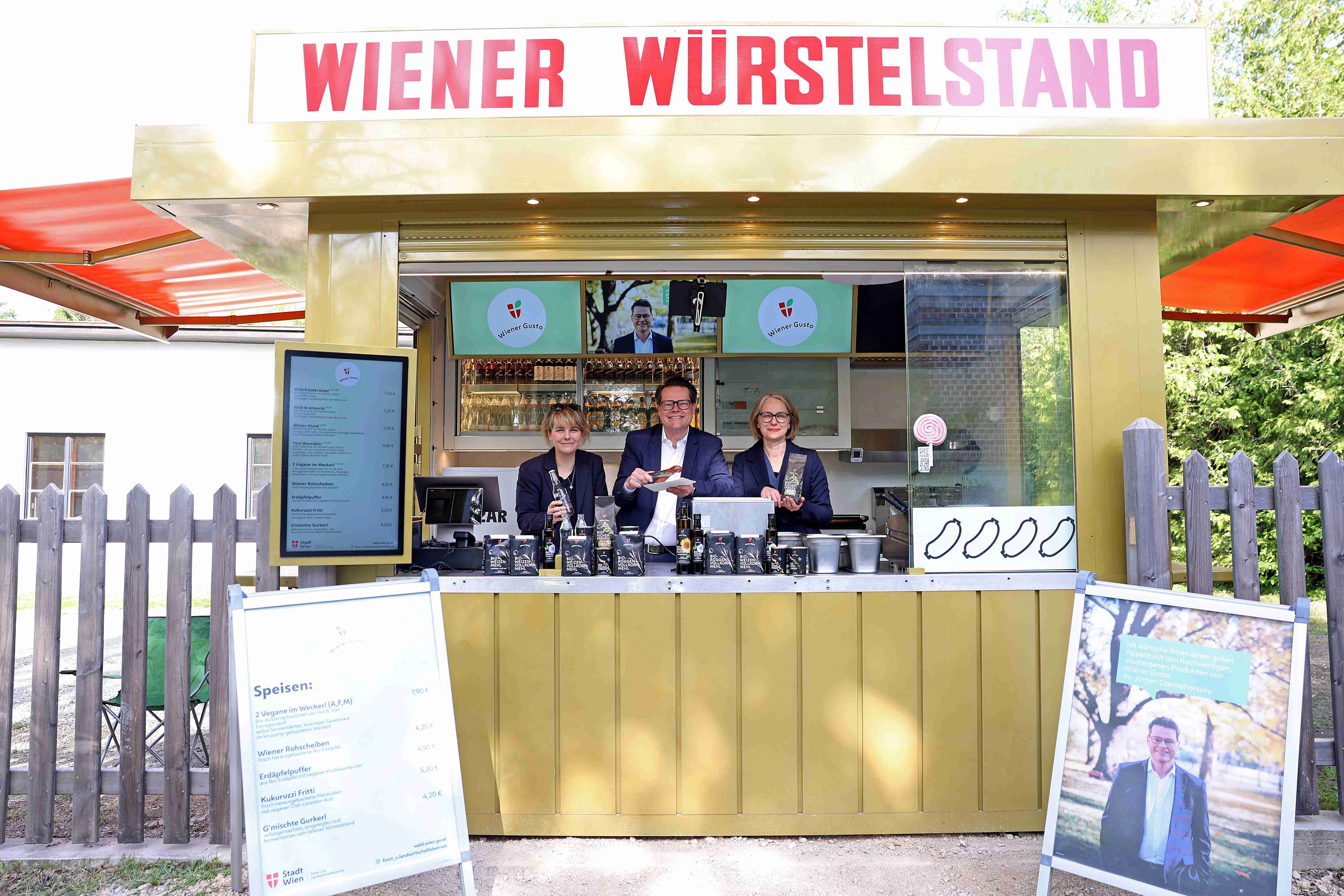 Bezirksvorsteherin Stefanie Lamp,&nbsp;Stadtrat Jürgen Czernohorszky und Bezirksvorsteherin Michaela Schüchner ließen sich ein Würstel schmecken.