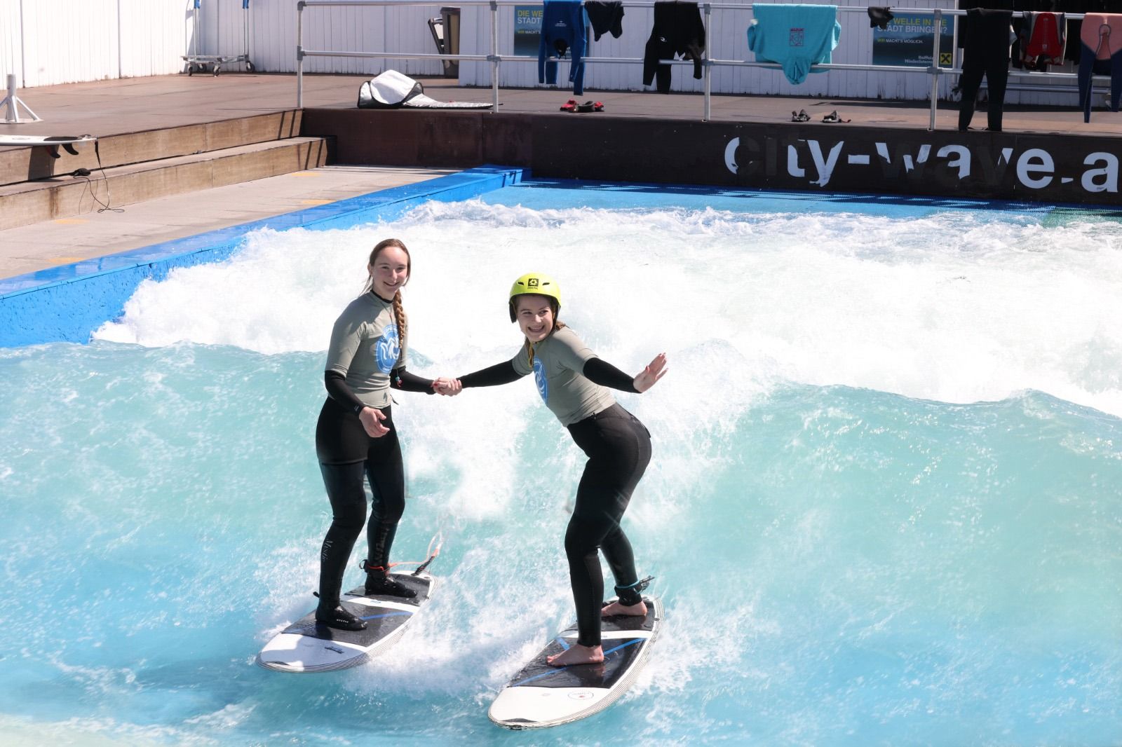 Profisurferin Gretchen Steiner reicht unterstützend eine helfende Hand beim Surfen.