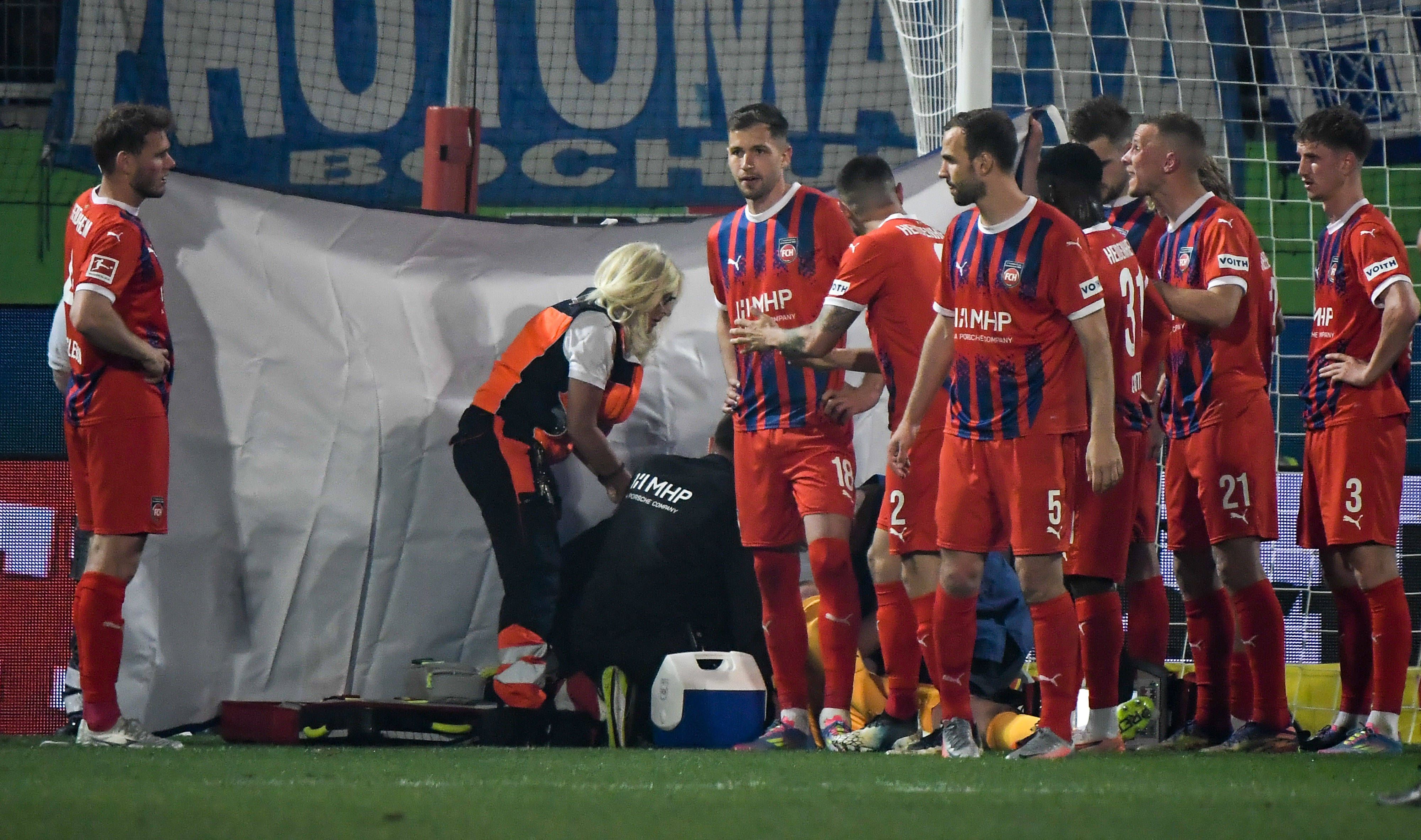 Teamärzte und Sanitäter kümmern sich um Heidenheim-Keeper Kevin Müller. . 