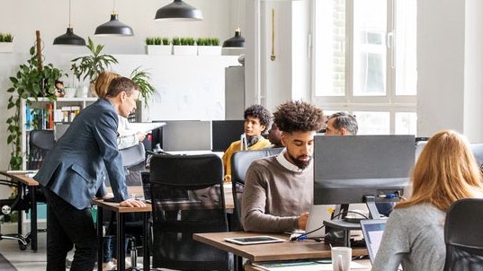 Business people working at desks. Male and female professionals working in modern office space.
