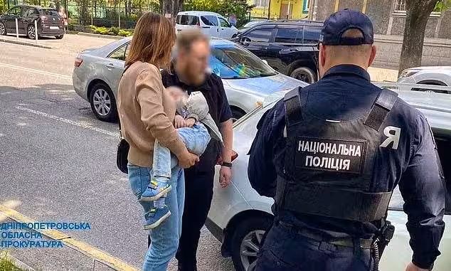 Eine 20-jährige Mutter in der Ukraine wollte ihren zweijährigen Sohn für rund 21.000 Euro verkaufen: Eine Sozialarbeiterin trägt das Kind zu einem Auto, um den Buben in Obhut zu nehmen.