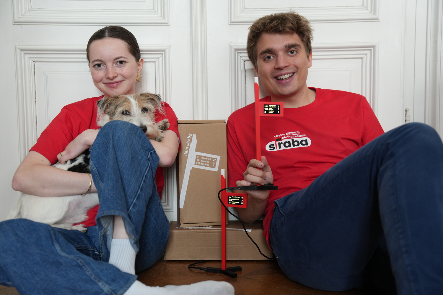 Straba-Gründer Elli und Paul mit Moodmanager Emil – und ihrer Mini-Haltestelle, die Wiens Öffis auf den Schreibtisch bringt.